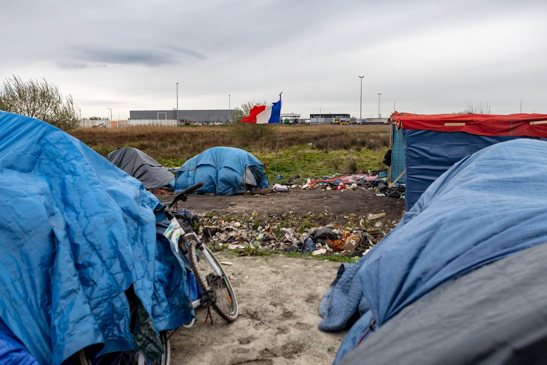 Un drapeau français flotte à la lisière du campement informel appelé « Old Lidl », à la périphérie de Calais (MEE/Marta Maroto)