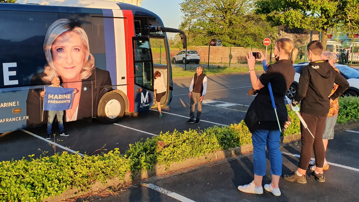 Des partisans de Marine Le Pen lors d’un rassemblement à Arras se rassemblent autour d’un bus de campagne pour prendre des photos (Frank Andrews/MEE)