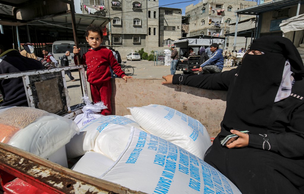 Palestinians receive UN food aid in Gaza’s Khan Younis camp on 7 March (AFP)