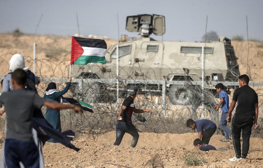 Palestinians confront Israeli security forces along the Gaza fence in 2019 (AFP)