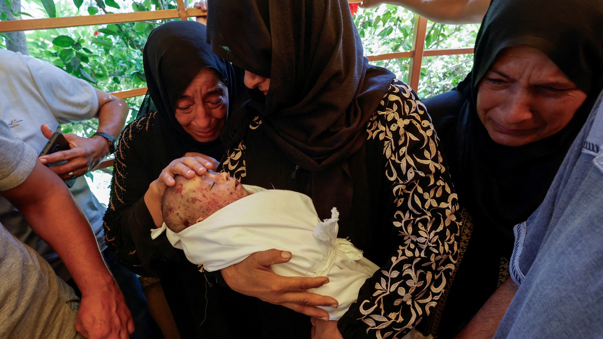 Relatives mourn as they hold the body of a Palestinian infant killed in the Israeli strike on al-Mawasi on 10 September (Reuters/Mohammed Salem)