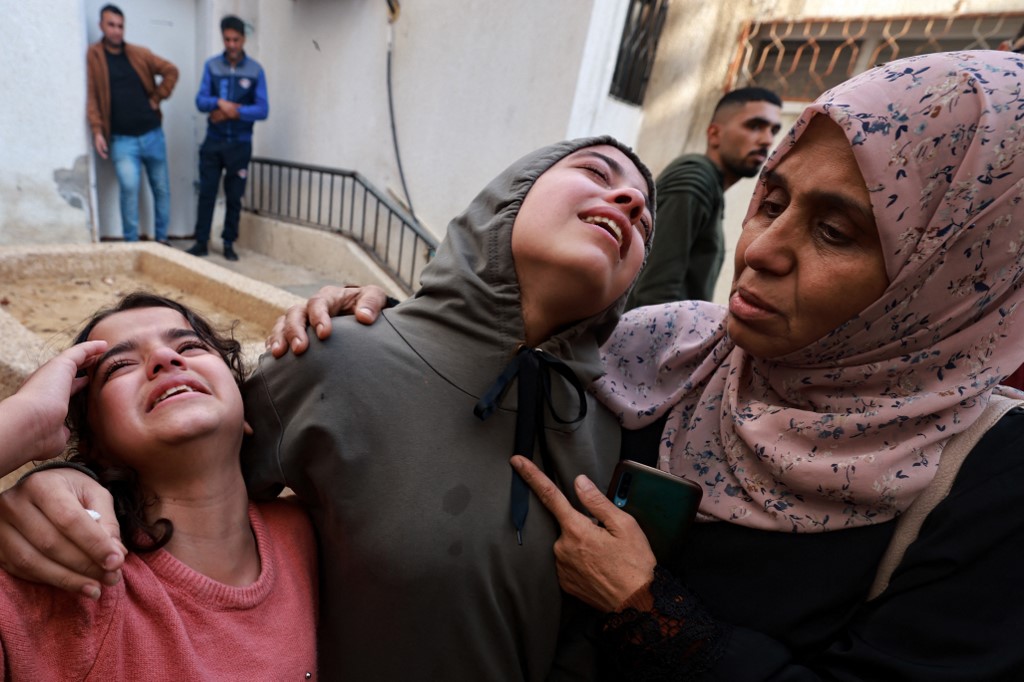 Family members mourn a baby girl killed in an Israeli strike in Rafah in the southern Gaza Strip, in the courtyard of the al-Najjar hospital on December 1, 2023,