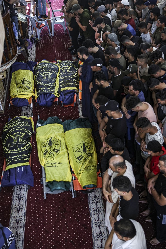 Des Palestiniens veillent les corps des victimes des frappes aériennes israéliennes sur Rafah, à l’intérieur d'une mosquée, le 7 août 2022 (AFP/Said Khatib)