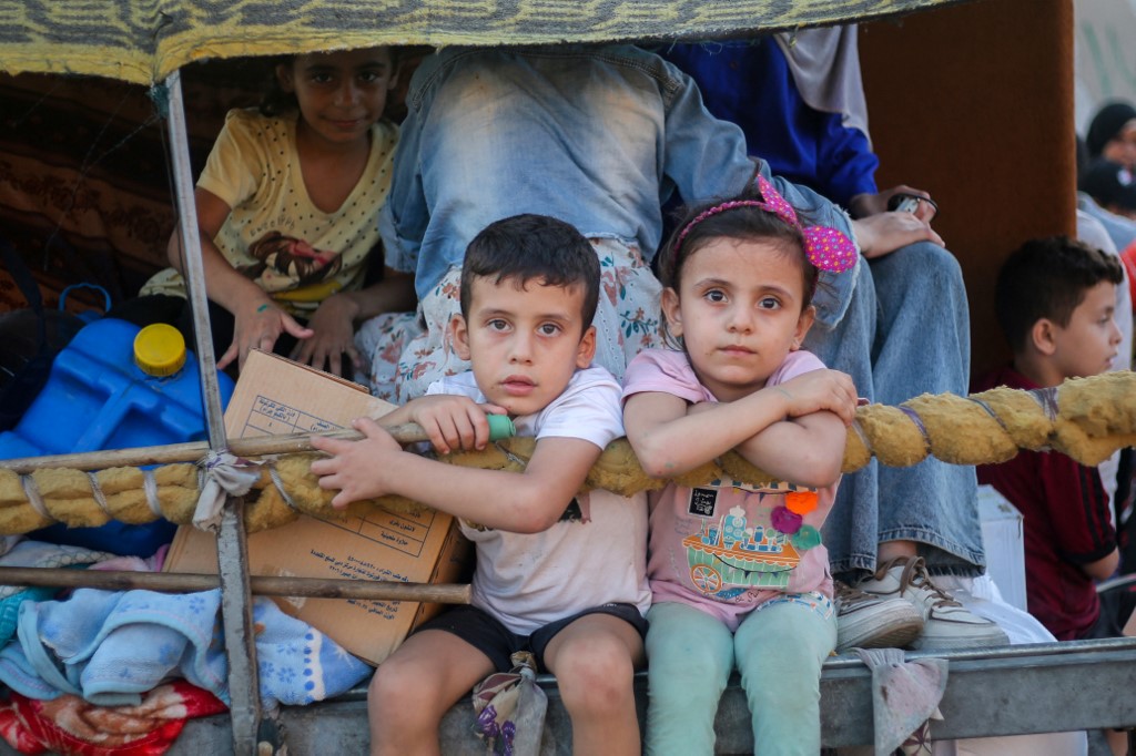 Children ride in the back of a TukTuk as Palestinians flee the al-Bureij refugee camp in the central Gaza Strip on July 28, 2024, amid the ongoing conflict between Israel and the Palestinian militant group Hamas.