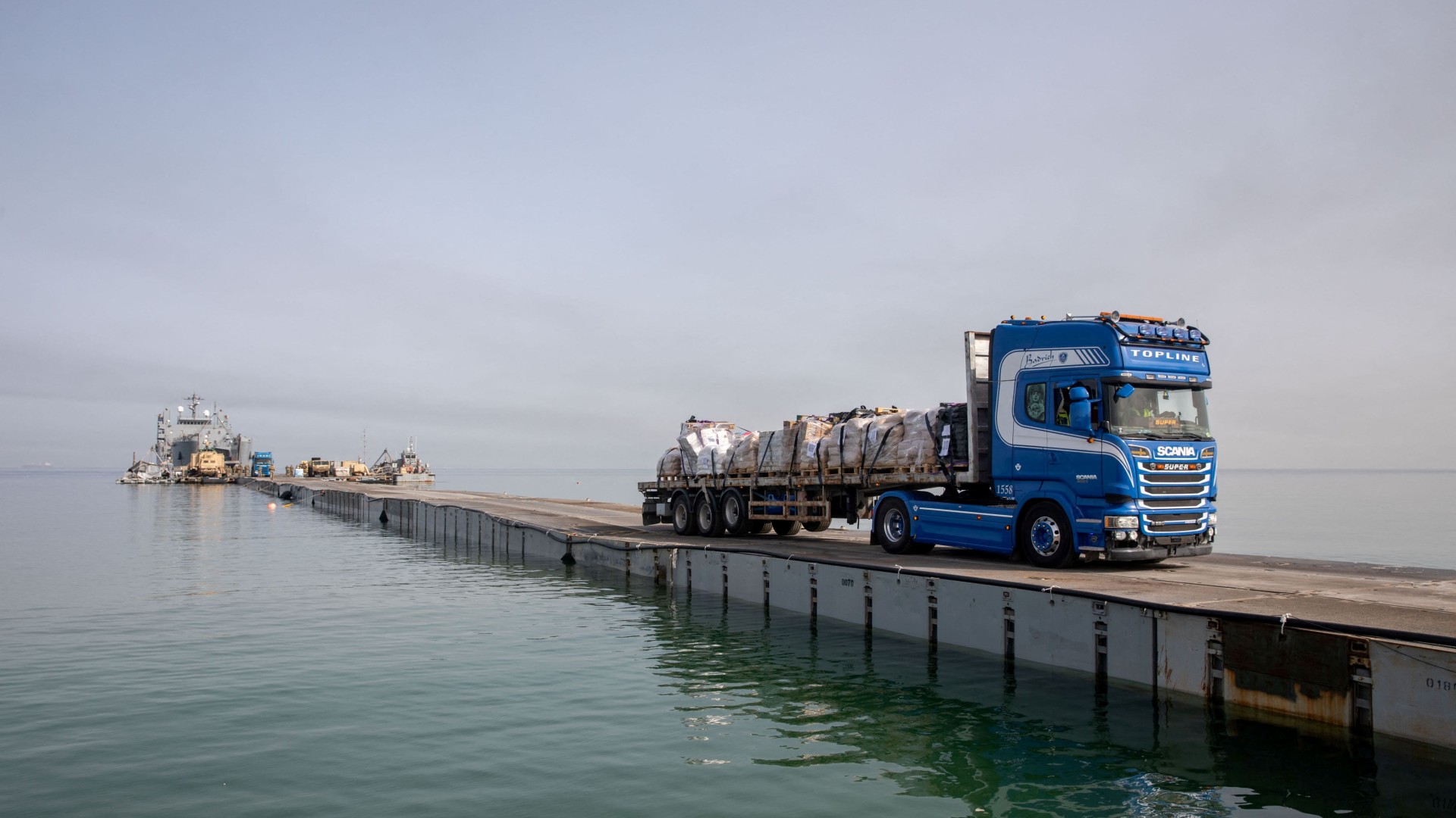 A truck carries humanitarian aid across Trident Pier, a temporary pier to deliver aid, off the Gaza Strip, amid the ongoing conflict between Israel and Hamas, near the Gaza coast, May 19, 2024