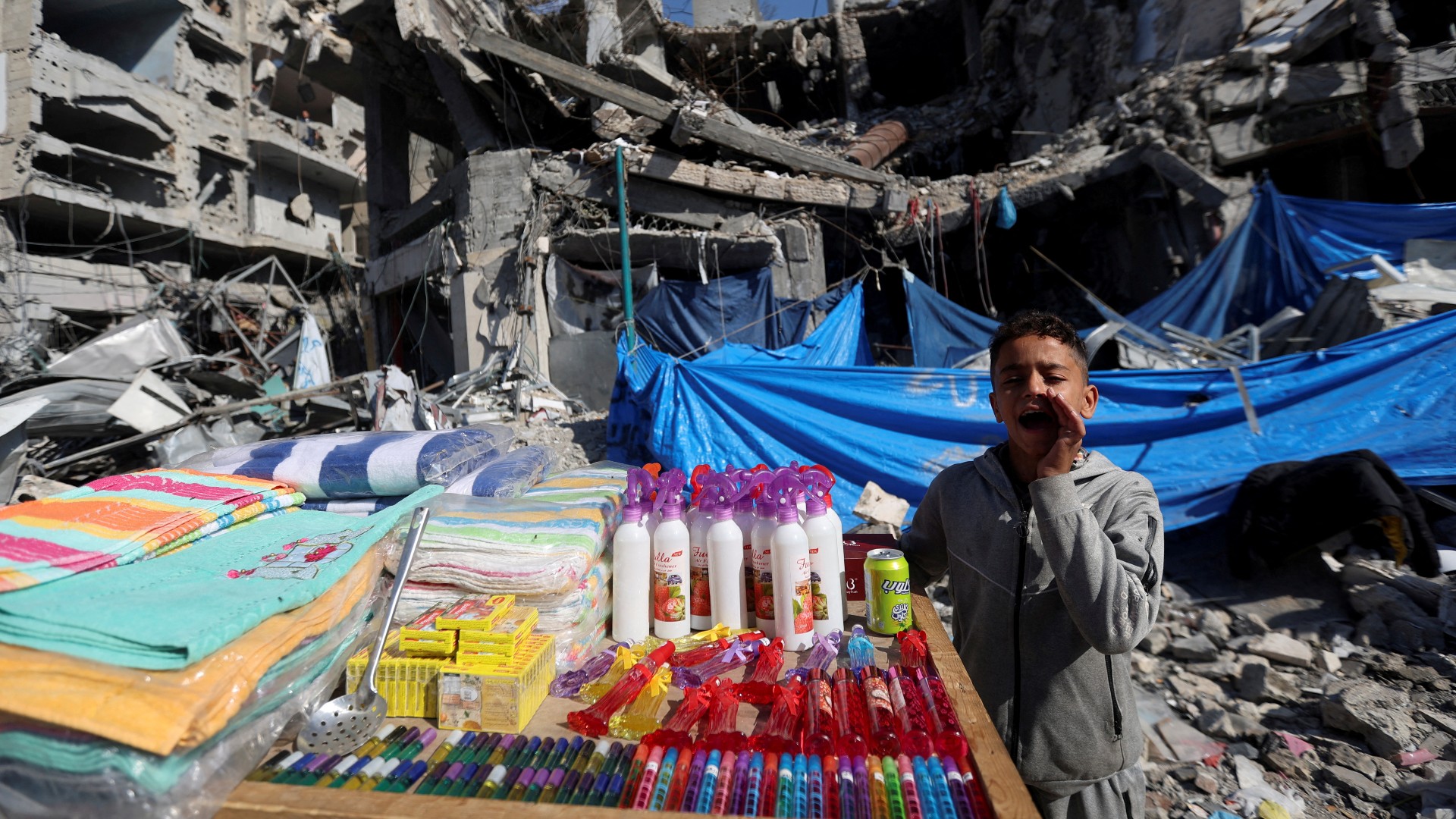 A Palestinian vendor offers his products in an open-air market near the ruins of houses and buildings destroyed in Israeli strikes during the conflict, amid a temporary truce between Hamas and Israel, in Nuseirat refugee camp in the central Gaza Strip November 30, 2023.