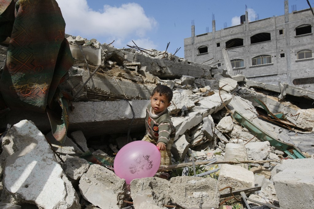 Un Palestinien joue dans les décombres de sa maison, détruite par les forces israéliennes à Gaza pendant la guerre de décembre 2008 – janvier 2009 (AFP)