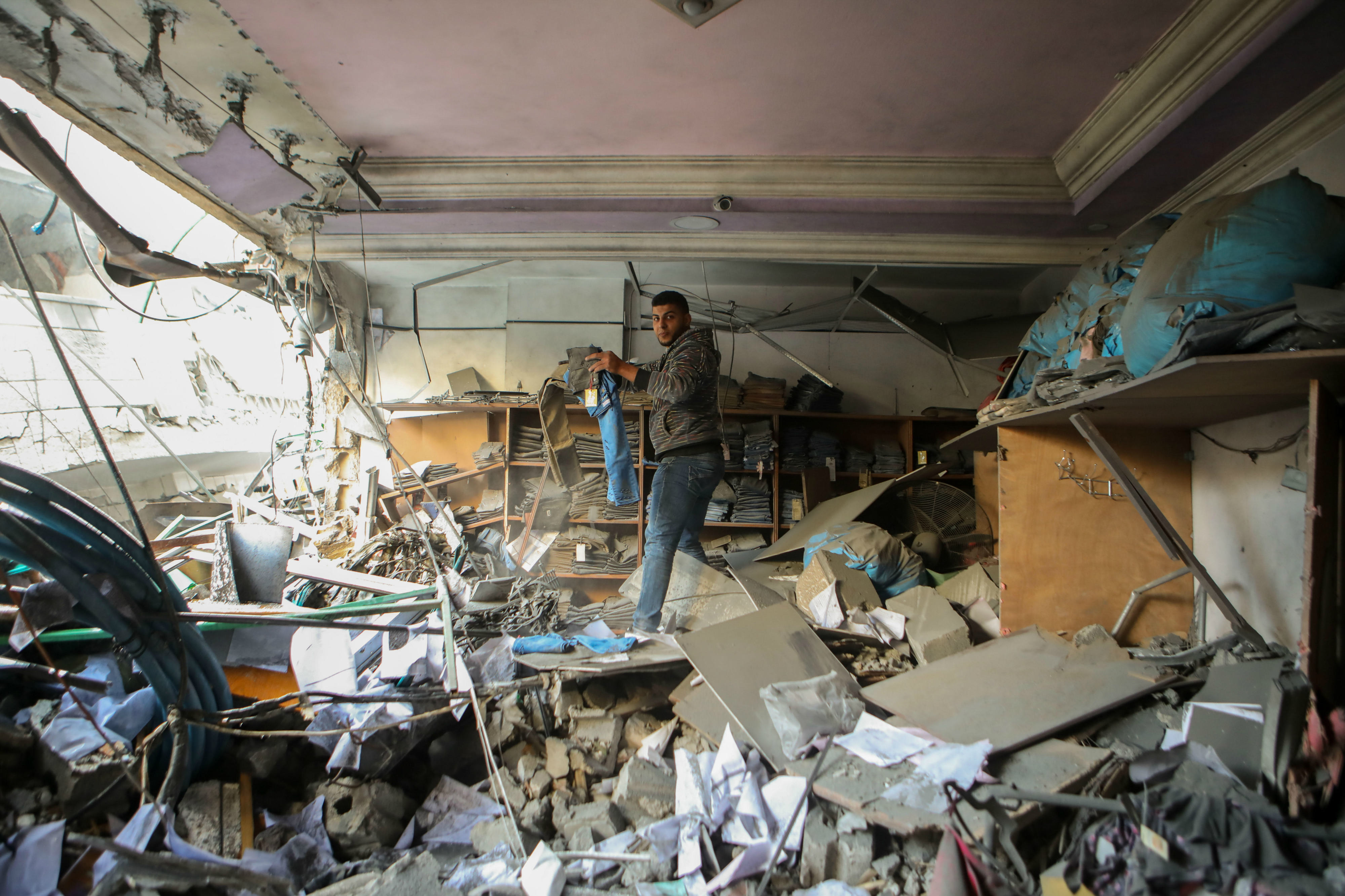 A Palestinian man in his home wrecked after Israeli strikes the day before (MEE/Mohammed al-Hajjar)