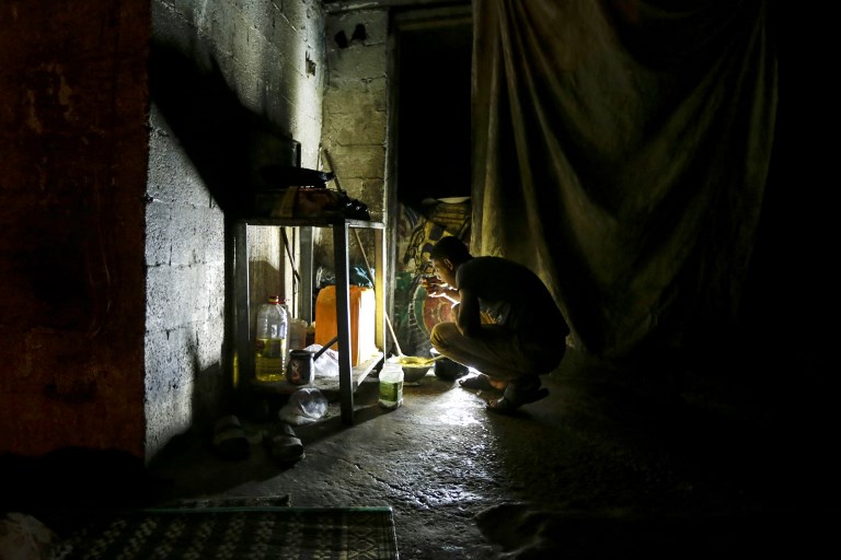A Palestinian man eats during a power cut in Gaza City in September 2017 (AFP)