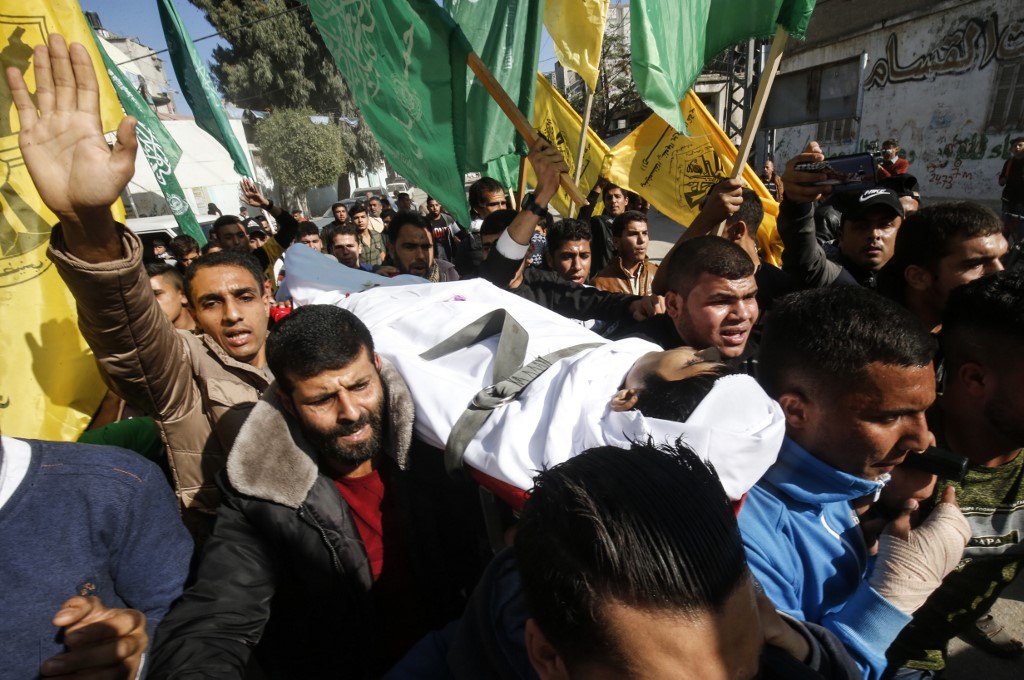 Mourners carry the body of a Palestinian teenager killed in Gaza on 30 November (AFP)