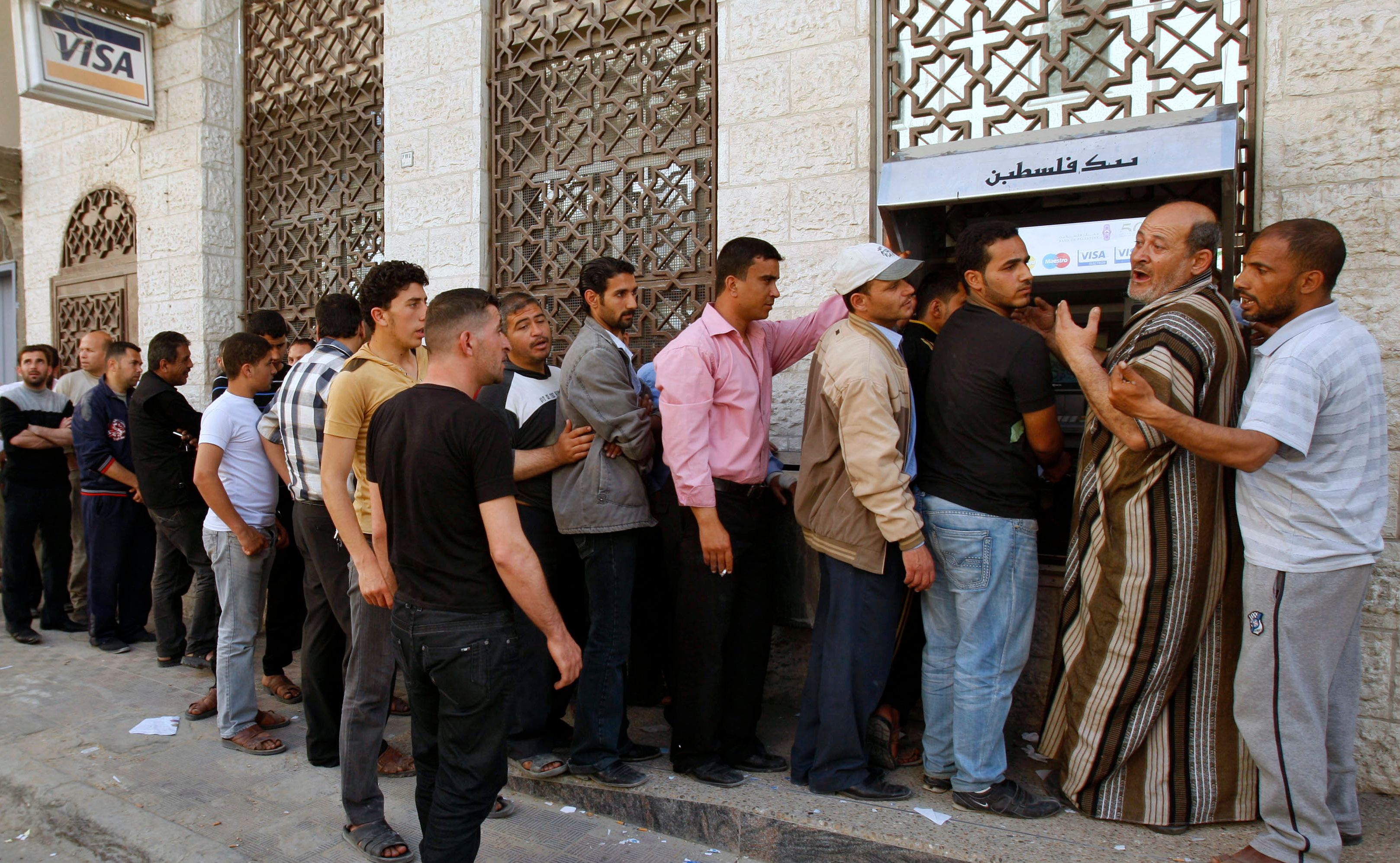 Des employés de l’Autorité palestinienne font la queue pour récupérer leur salaire à un guichet automatique, à Khan Younès (bande de Gaza), en avril 2012 (Reuters)