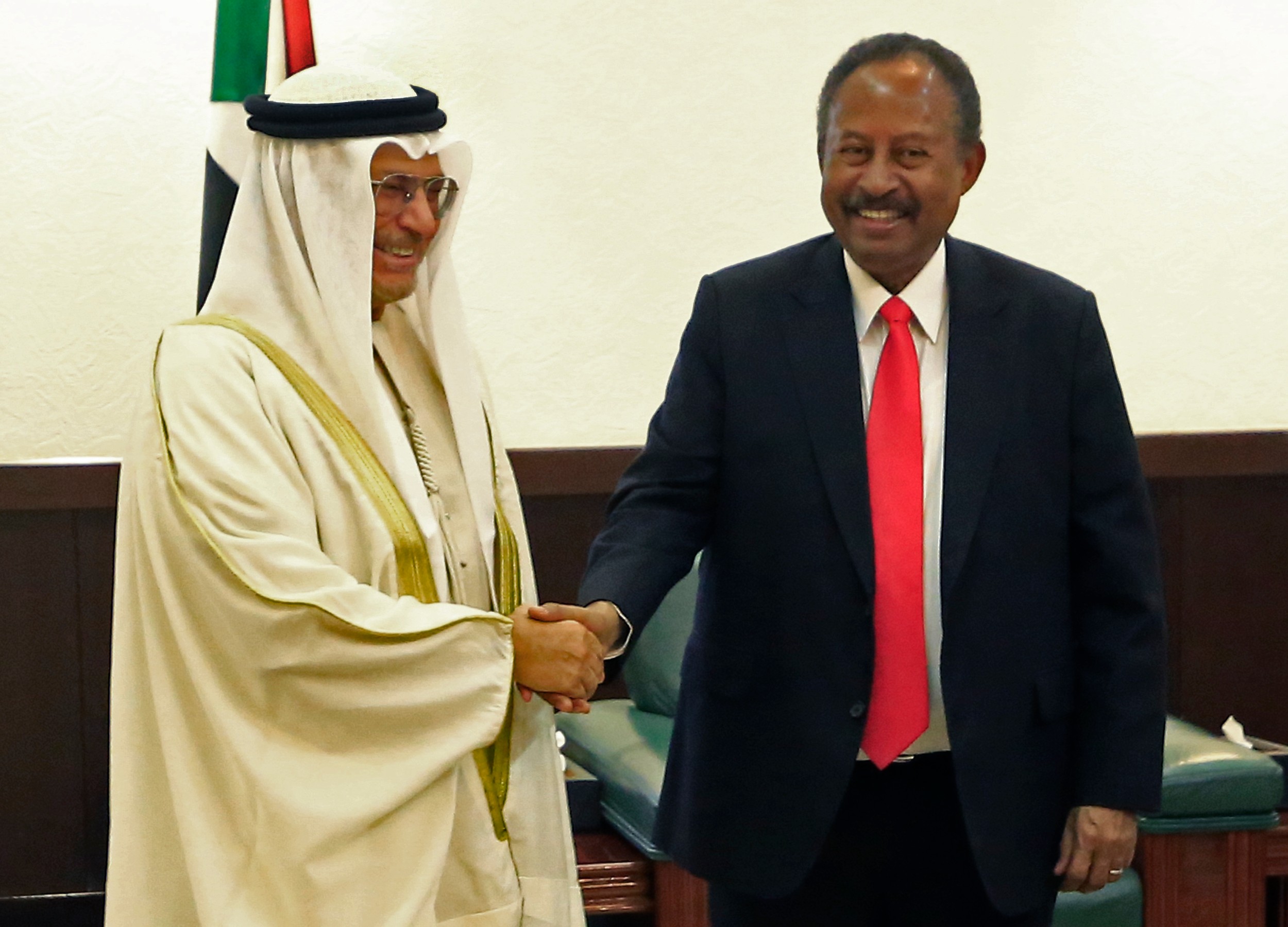 Sudan Prime Minister Abdalla Hamdok shakes hands with UAE Foreign Affairs Minister Anwar Gargash in Khartoum on 14 January. The UAE reportedly facilitated the Burhan-Netanyahu meeting (AFP)