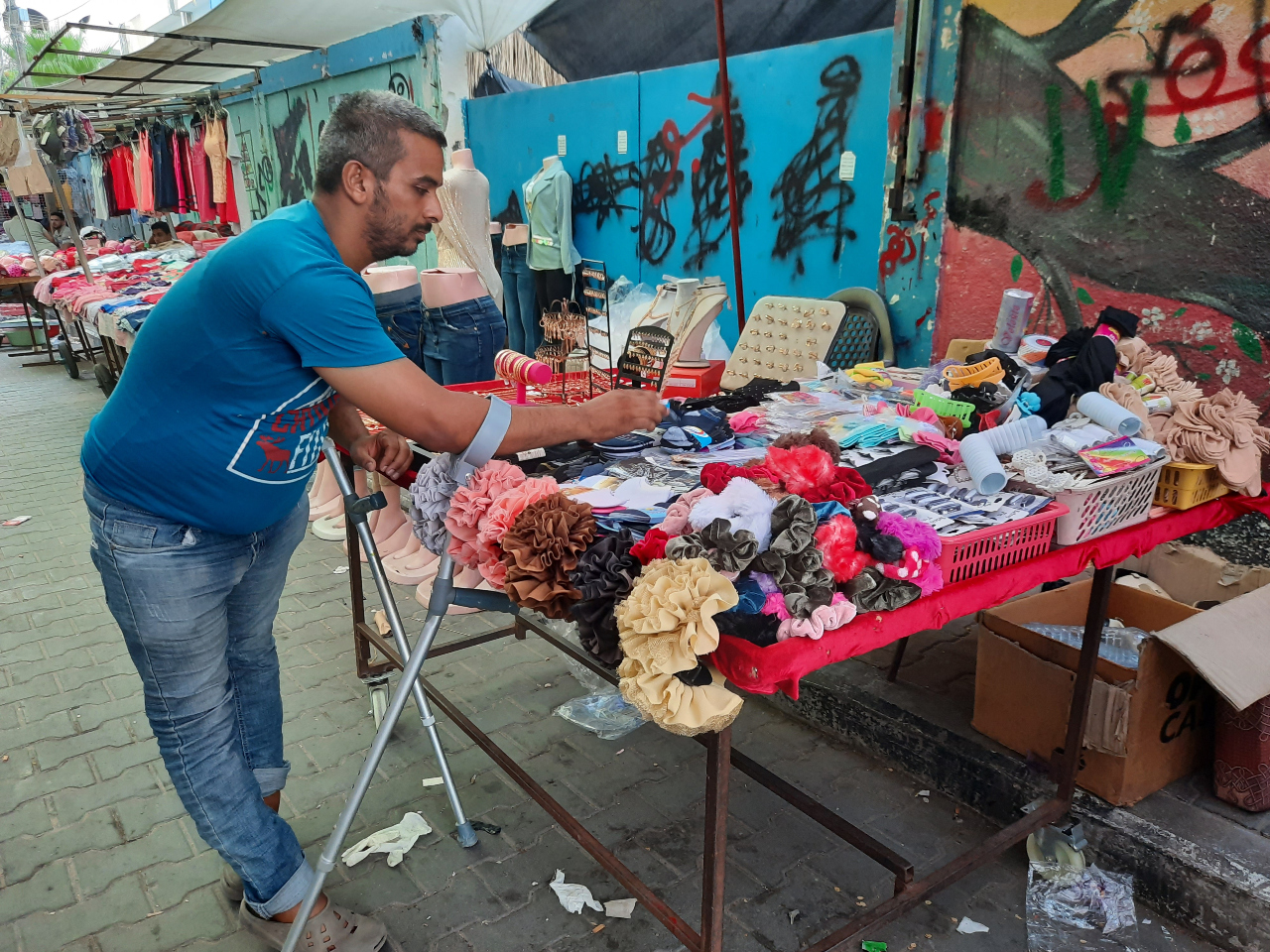 Mohamed al-Amarin, qui tient un étal sur le marché, souffre de paralysie cérébrale et a un problème avec les nerfs de ses pieds (MEE/Ahmed Al-Sammak)