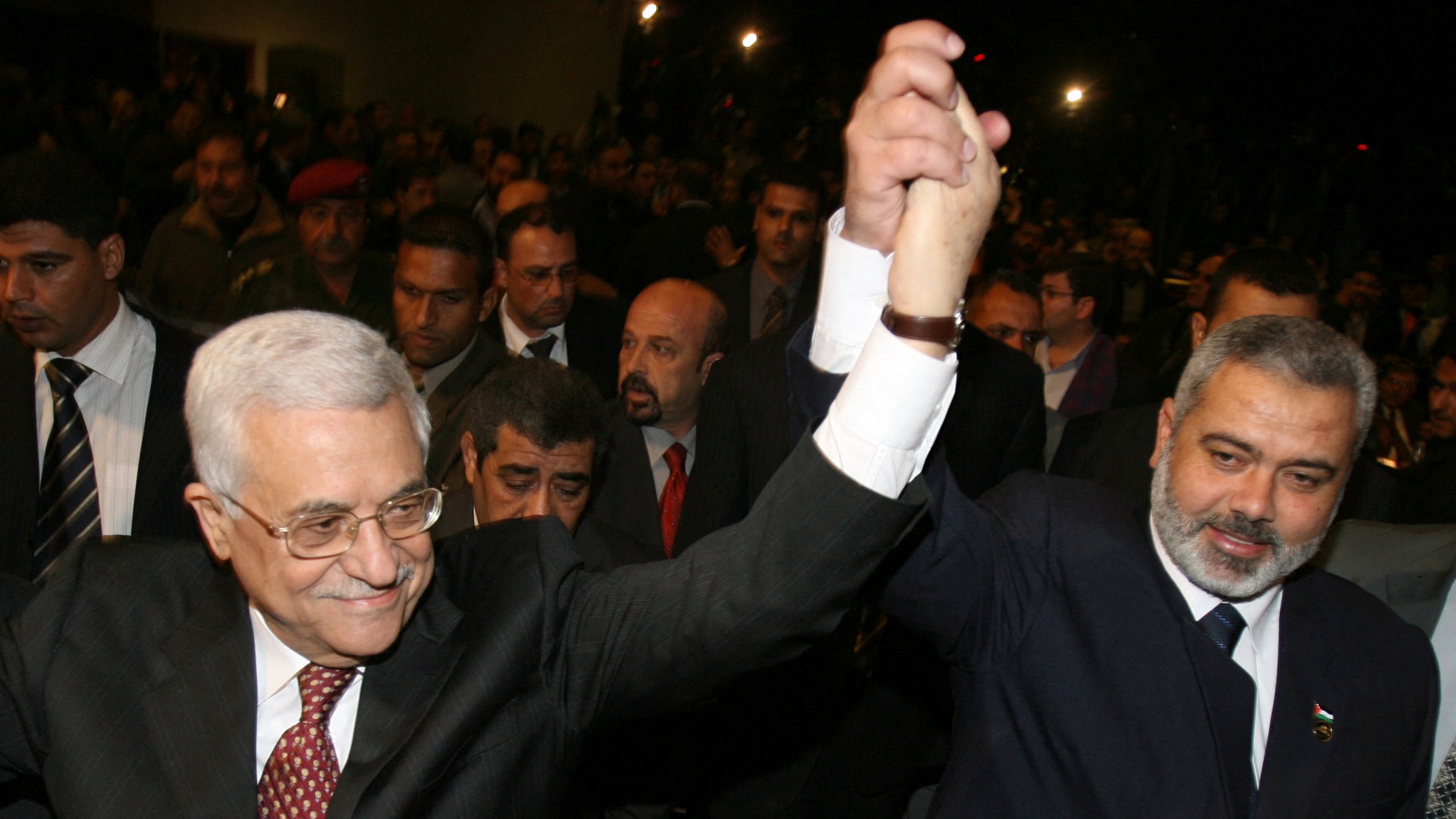 President Mahmoud Abbas holds hands with prime minister-designate Ismail Haniya at the start of a parliament session in Gaza City 17 March 2007 (AFP/Mahmud Hams)