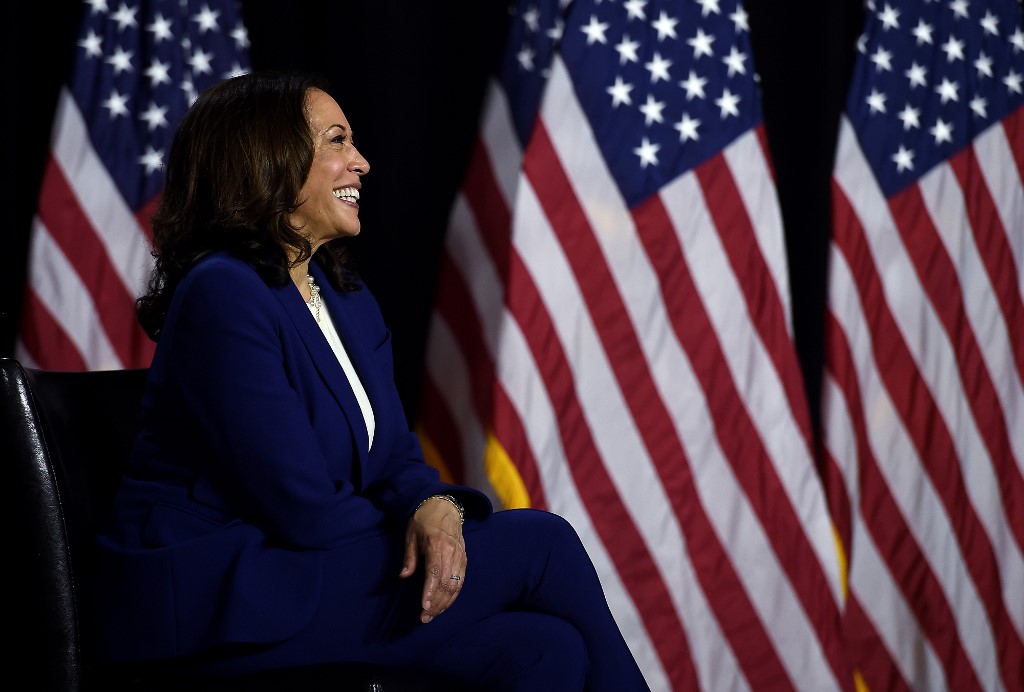 Harris listens to Biden speak during a news conference in Delaware on 12 August (AFP)
