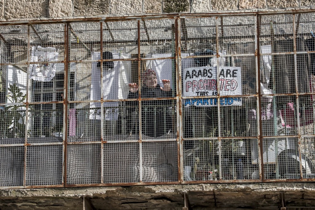 A sign reads ‘Arabs are prohibited, this is Apartheid St’ in Hebron on 28 January (AFP)