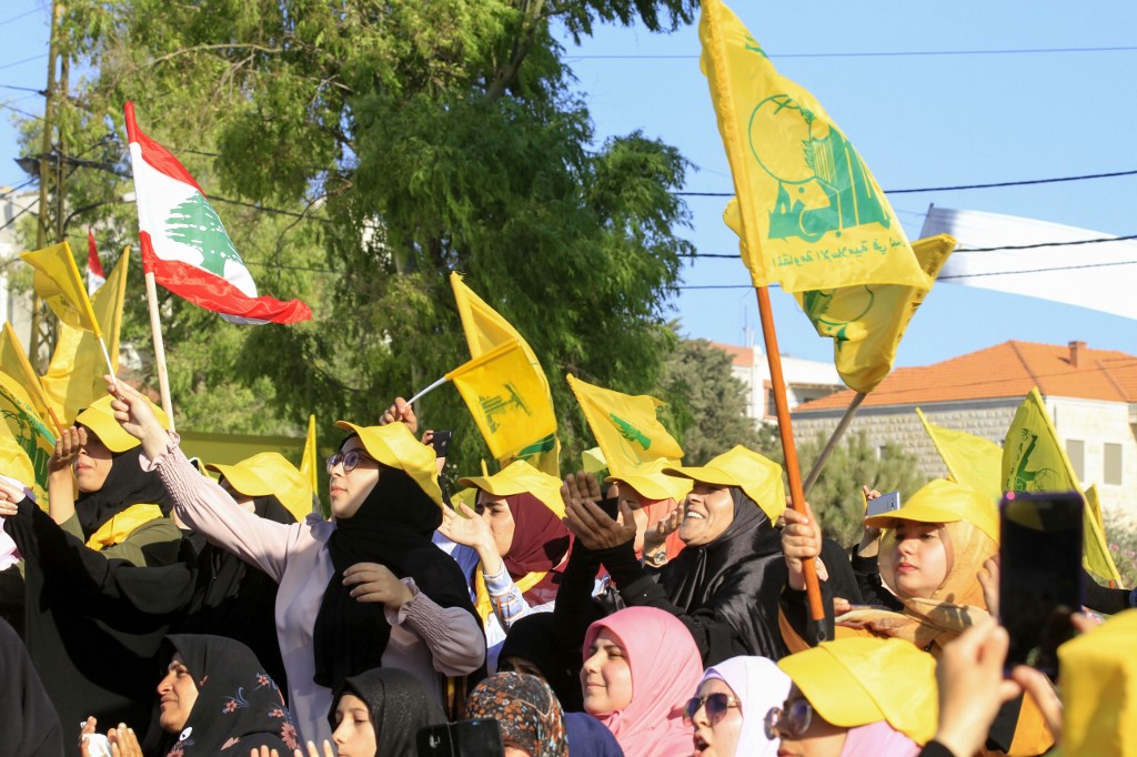 Supporters of Lebanon’s Hezbollah wave the group’s flag in Bint Jbeil on 16 August (AFP)