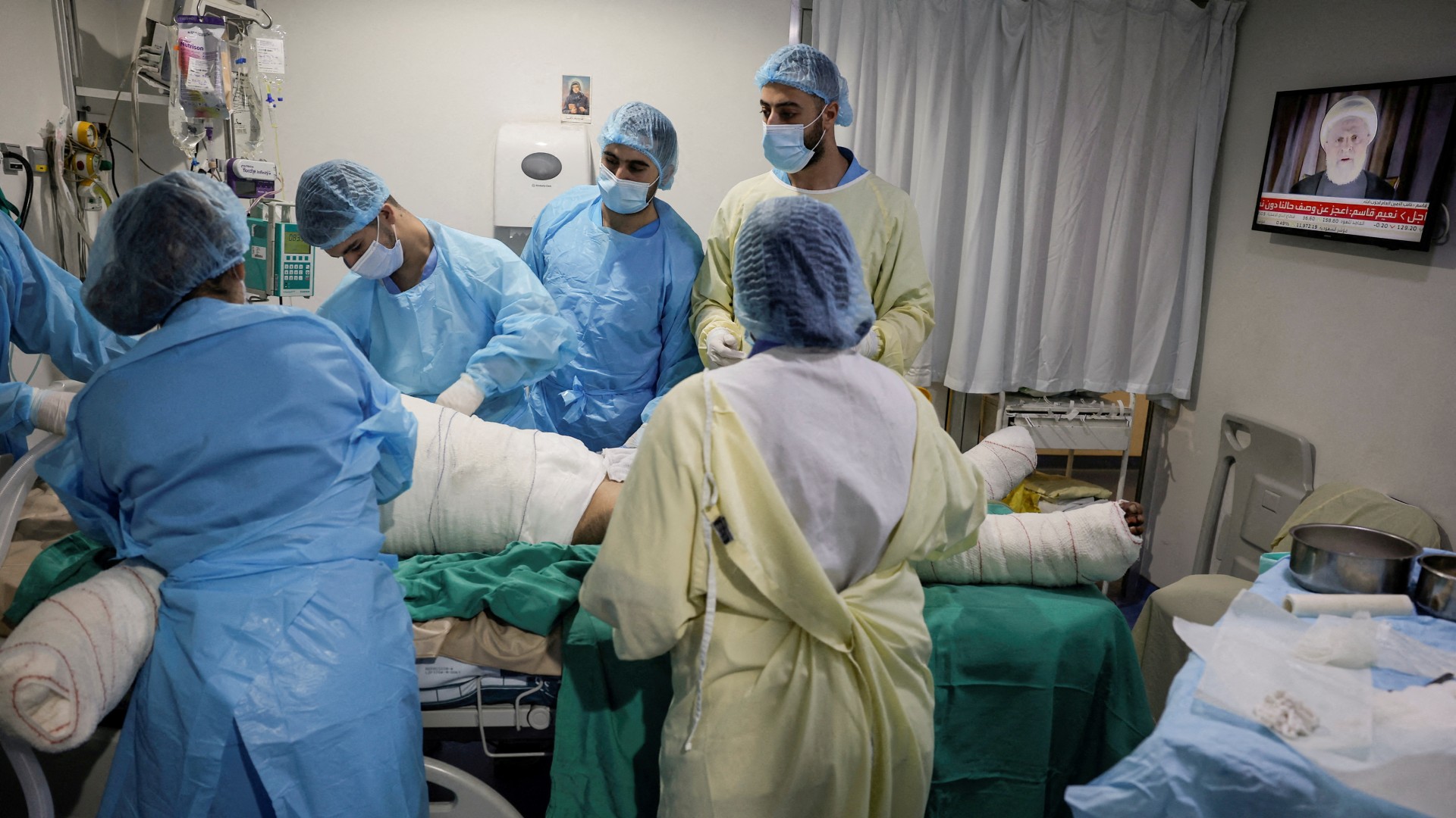 Medics attend to a casualty of an Israeli airstrike, in the ICU of Beirut's Geitaoui Hospital burns unit as Naim Qassem delivers a speech on TV, 8 October, 2024. (Reuters/Louisa Gouliamaki)