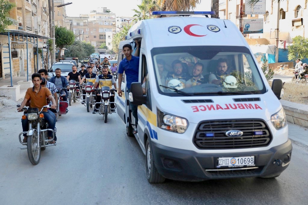 White Helmets and friends in funeral procession of citizen journalist Anas al-Dyab in Syria's Idlib on Sunday (AFP)