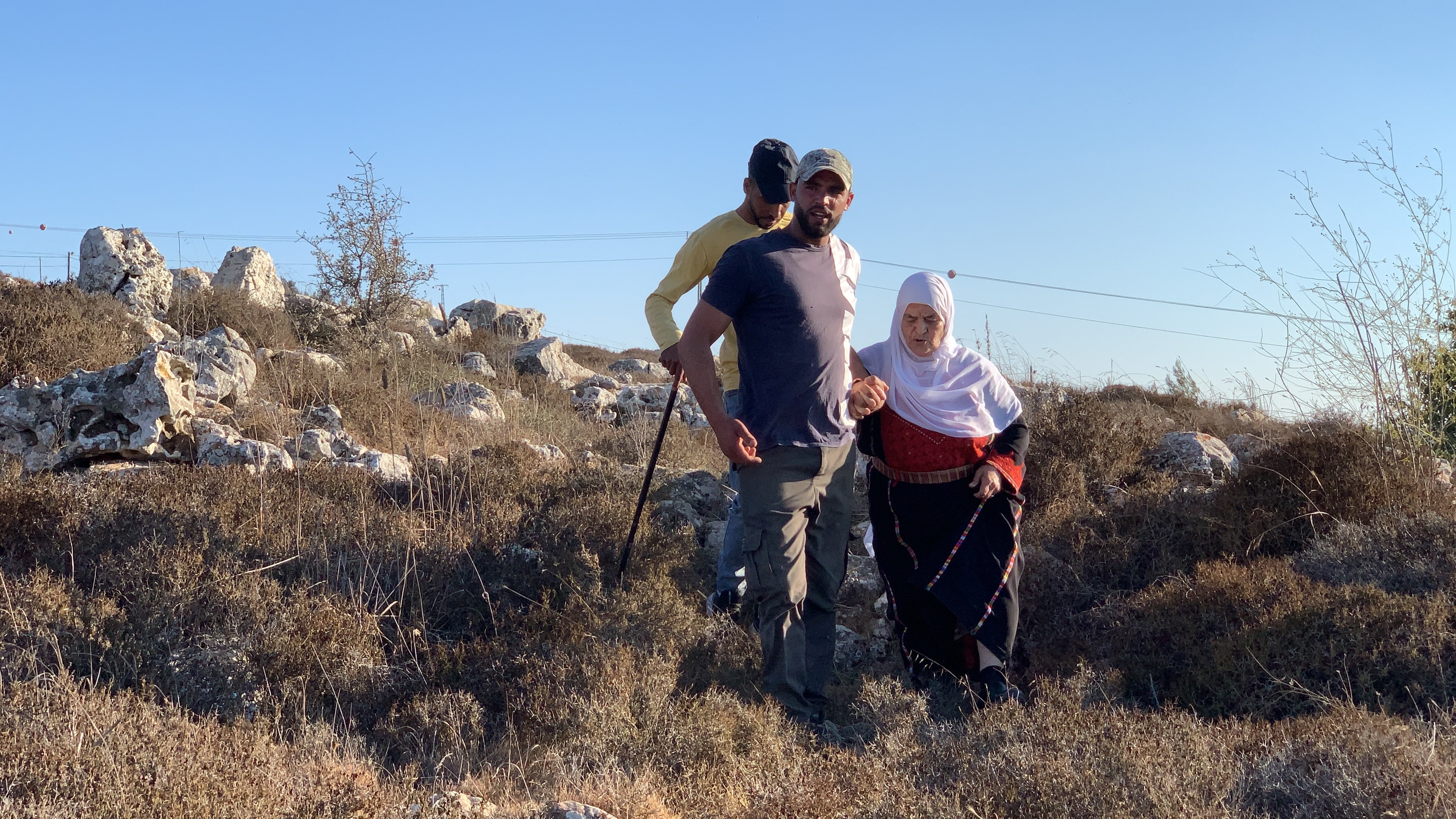 Mariam, accompagnée de deux de ses petits-enfants, tente d’accéder à leur terre dans la région de Thahr al-Mazare, le samedi 18 septembre 2021 (MEE/Shatha Hammad)