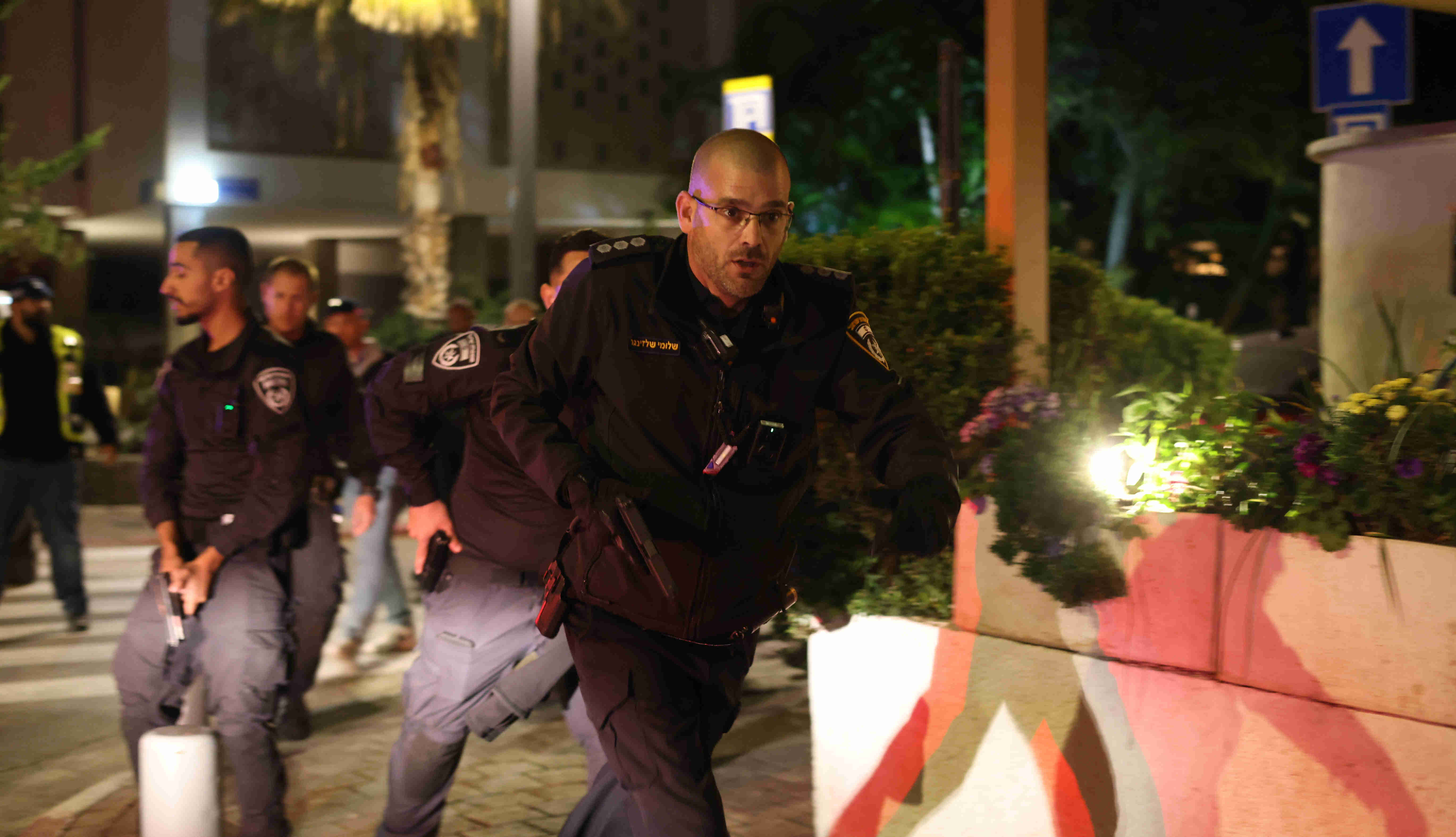 Un policier israélien cherche à sécuriser le lieu d’une fusillade à Tel Aviv le 9 mars 2023 (MEE/Oren Ziv)