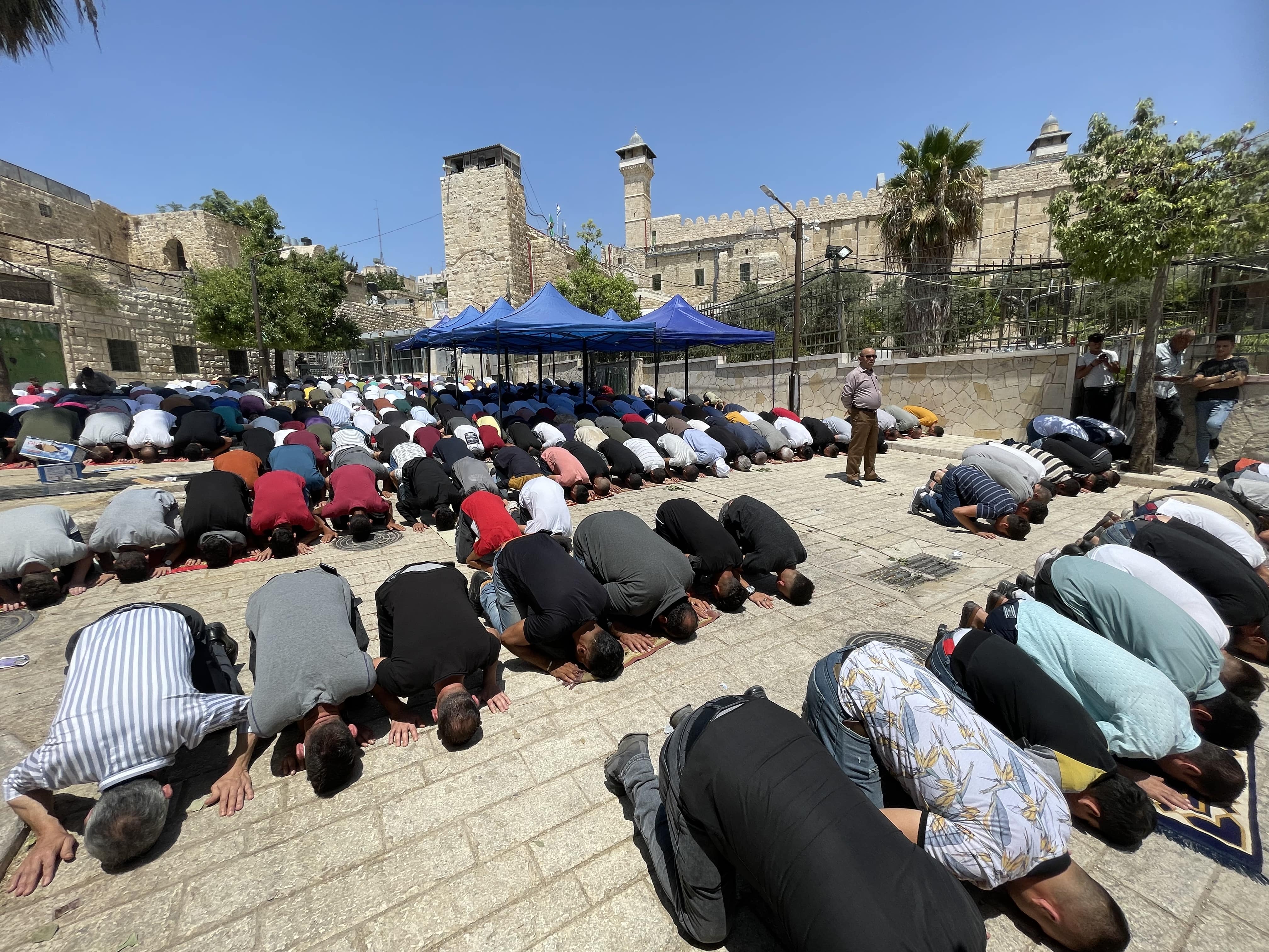 Palestinians perform Friday prayers in the outer courtyard of the Ibrahimi Mosque in Hebron after calls to attend daily prayers in protest against the elevator project 