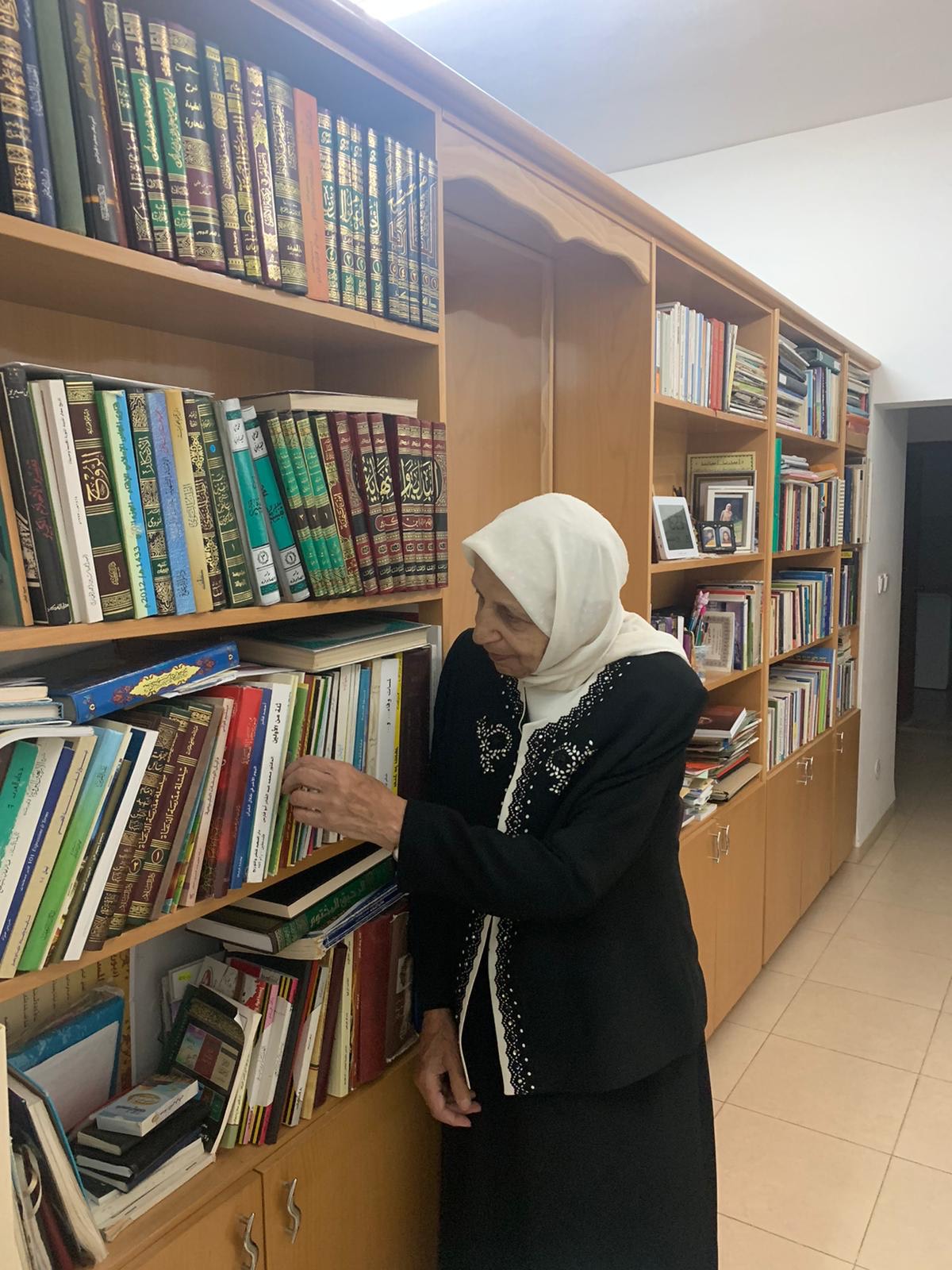 Jihad Mohammad Battu browsing a bookshelf (MEE/