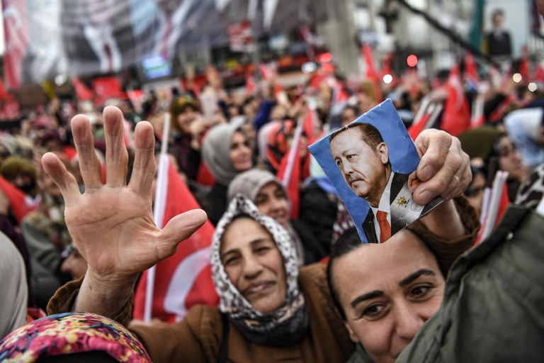 A woman holds a picture of Turkish President Recep Tayyip Erdogan at a rally in Istanbul (AFP)