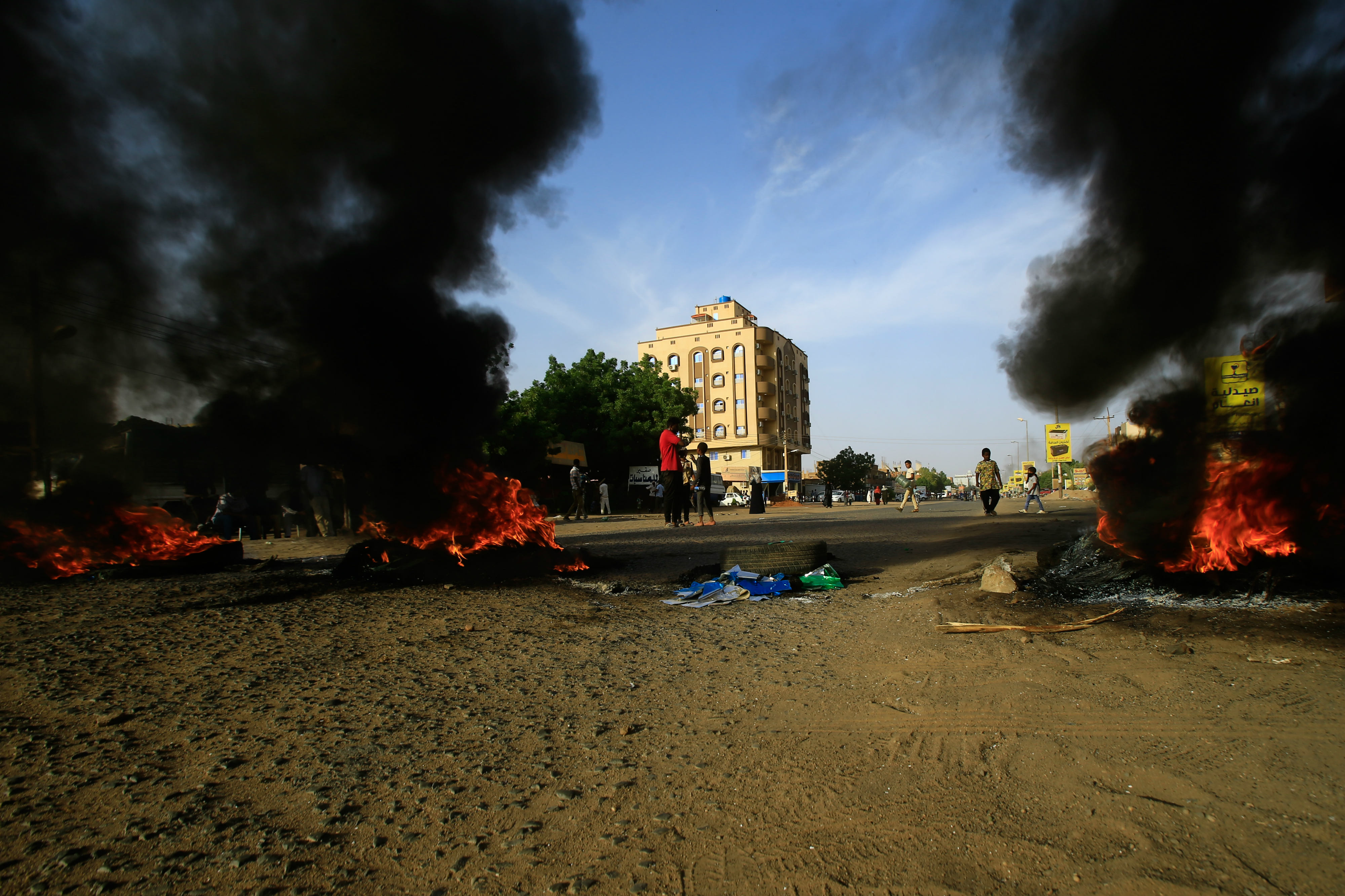 Demonstrators burn tires in the middle of a main street in Khartoum as they protest against the results of the probe into the June raid on a Khartoum protest camp (AFP)