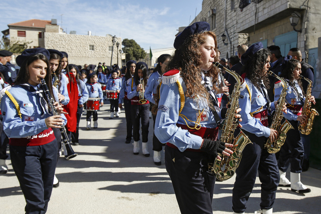 Palestinian scout troops perform during a parade ahead of the arrival of the Relic of the Holy Crib of the Child Jesus at the Church of the Nativity compound in Bethlehem (AFP)