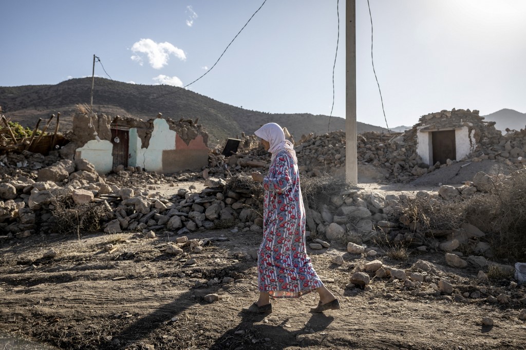 A woman walks past destroyed houses after an earthquake in the mountain village of Tafeghaghte, southwest of the city of Marrakesh, on September 9, 2023.