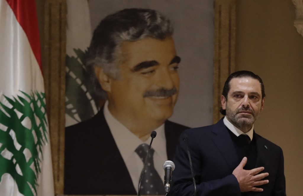 Saad Hariri announces he is departing politics in front of a portrait of his late father, Rafic Hariri (AFP)