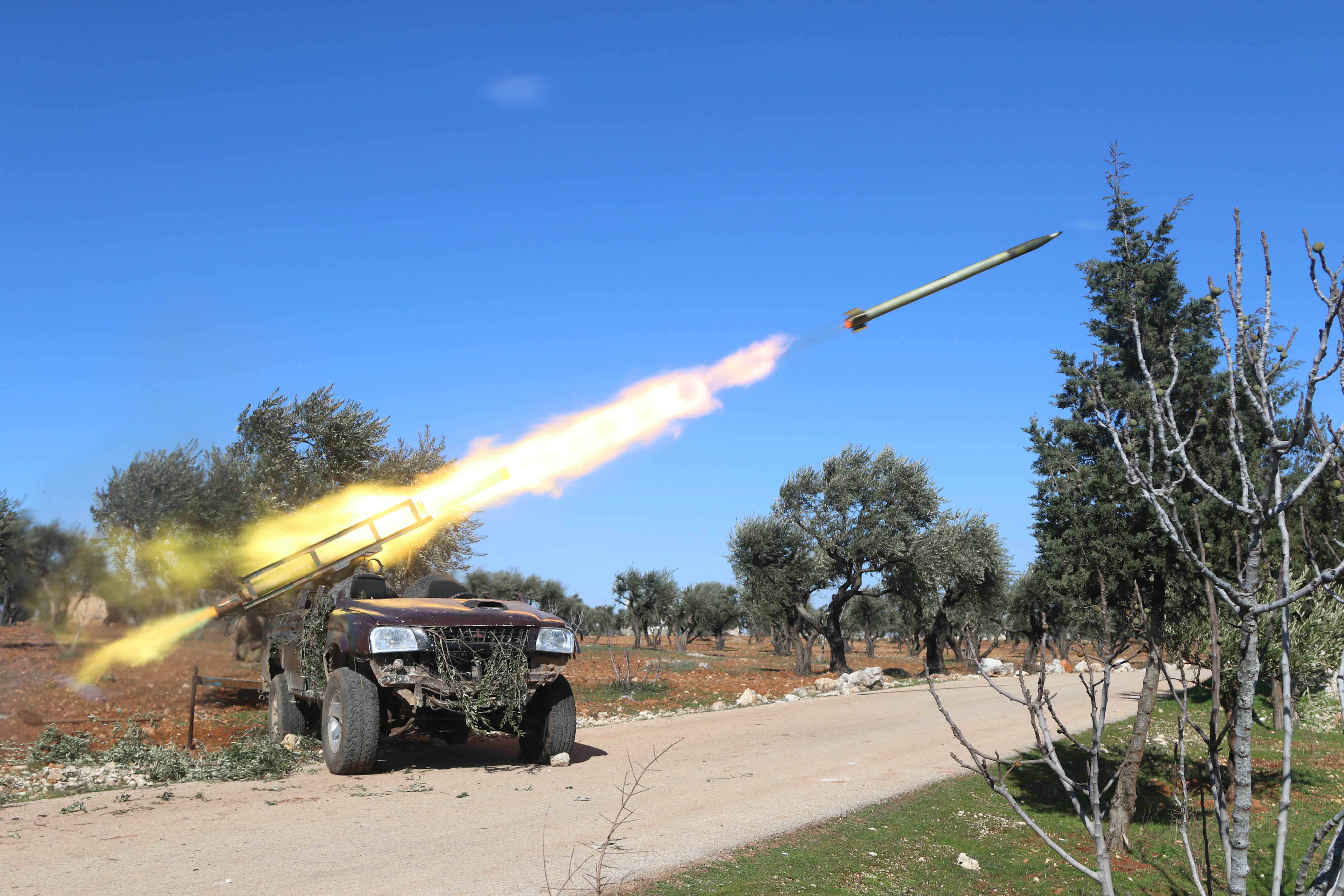 Rebels launch a Grad rocket at Syrian government positions in Talhia village in Syria's Idlib province (MEE/Abdulwajed Haj Esteifi)