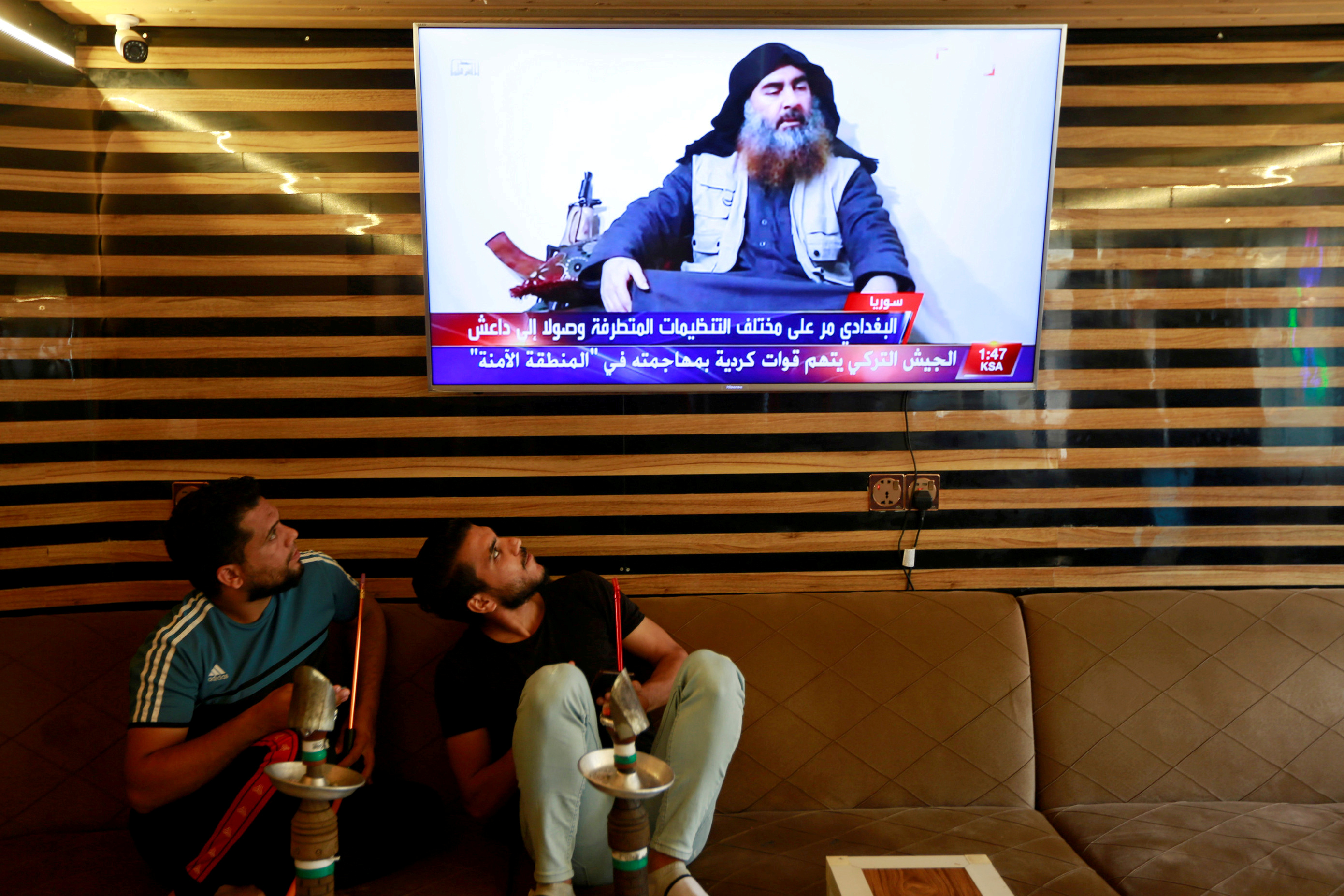 Two Iraqi youngmen in Najaf watching news of Baghdadi's death (Reuters)