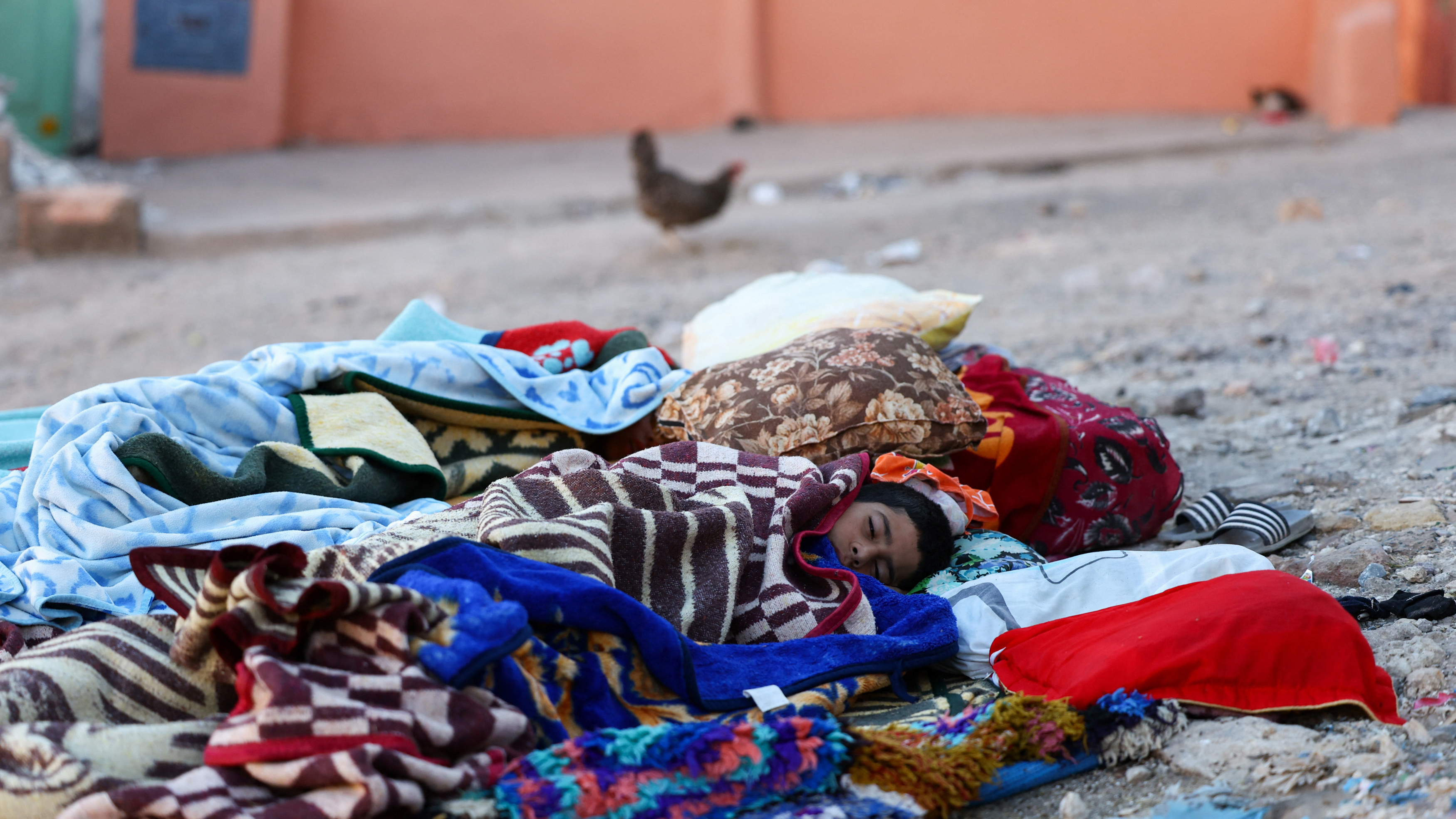 People rest on the ground in the aftermath of a deadly earthquake in Moulay Brahim, Morocco, 10 September 2023 (Reuters)