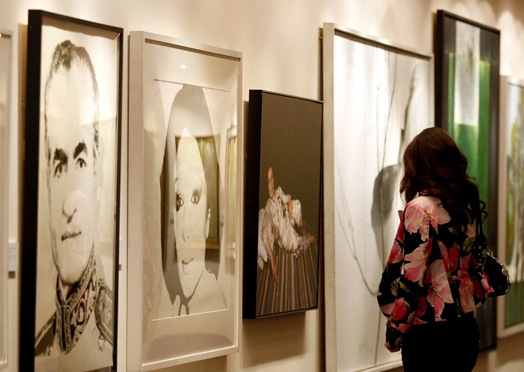 A woman looks at a piece of art by Andy Warhol showing the late Shah of Iran's wife Farah Pahlavi (C), exhibited in Dubai, 27 April 2008 (AFP)