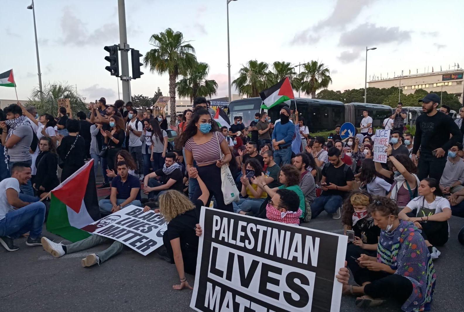 Protesters hold “Black Lives Matter” and “Palestinian Lives Matter” signs in Haifa, Israel, in June 2020 (MEE/Mohamad Kadan)