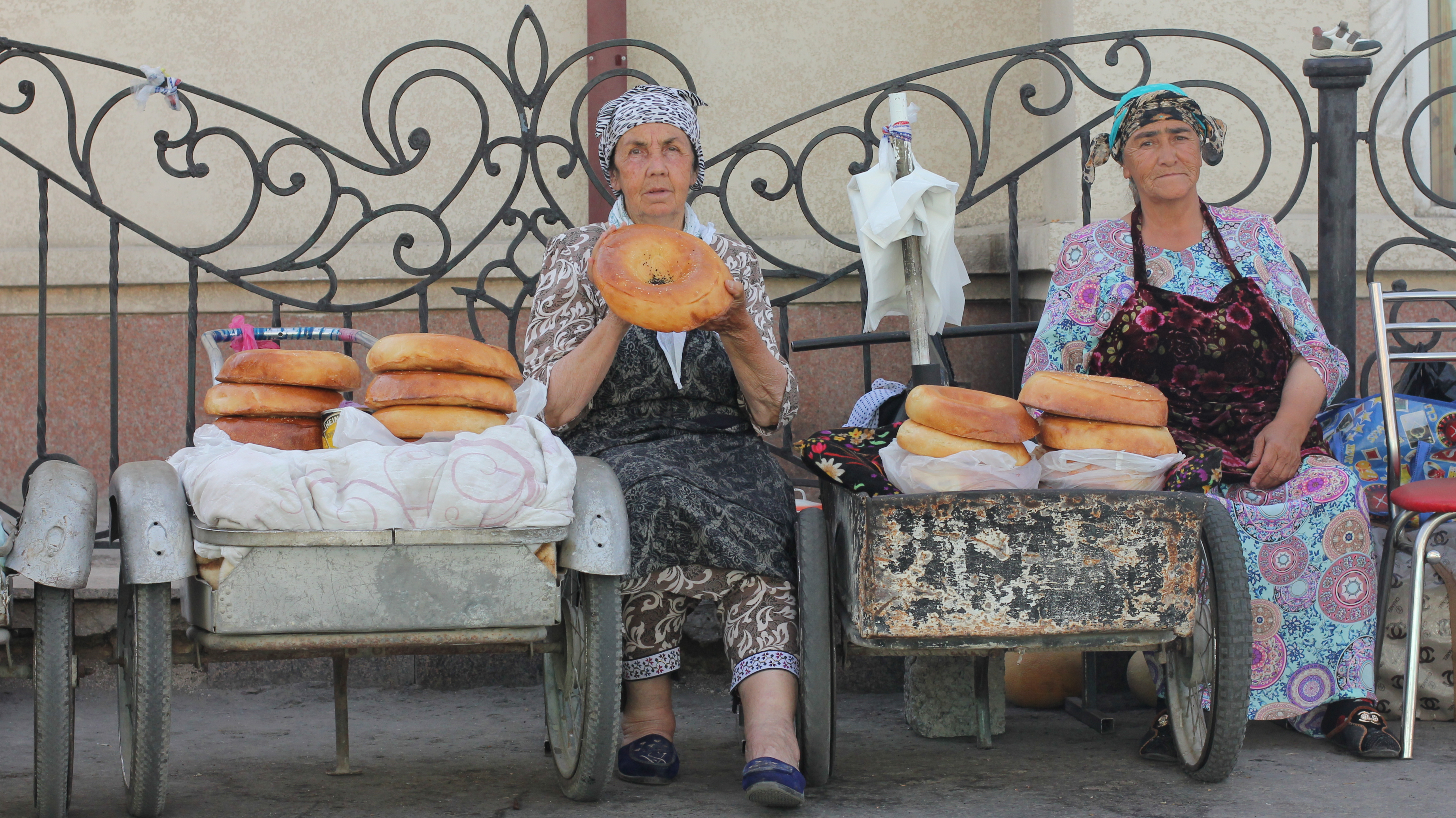Two Uzbek women sitting on a street in Samarkand sell the fabled Samarkand non.