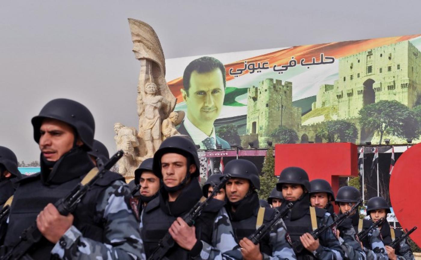 Syrian soldiers posing in front of a portrait of Syrian president (AFP)