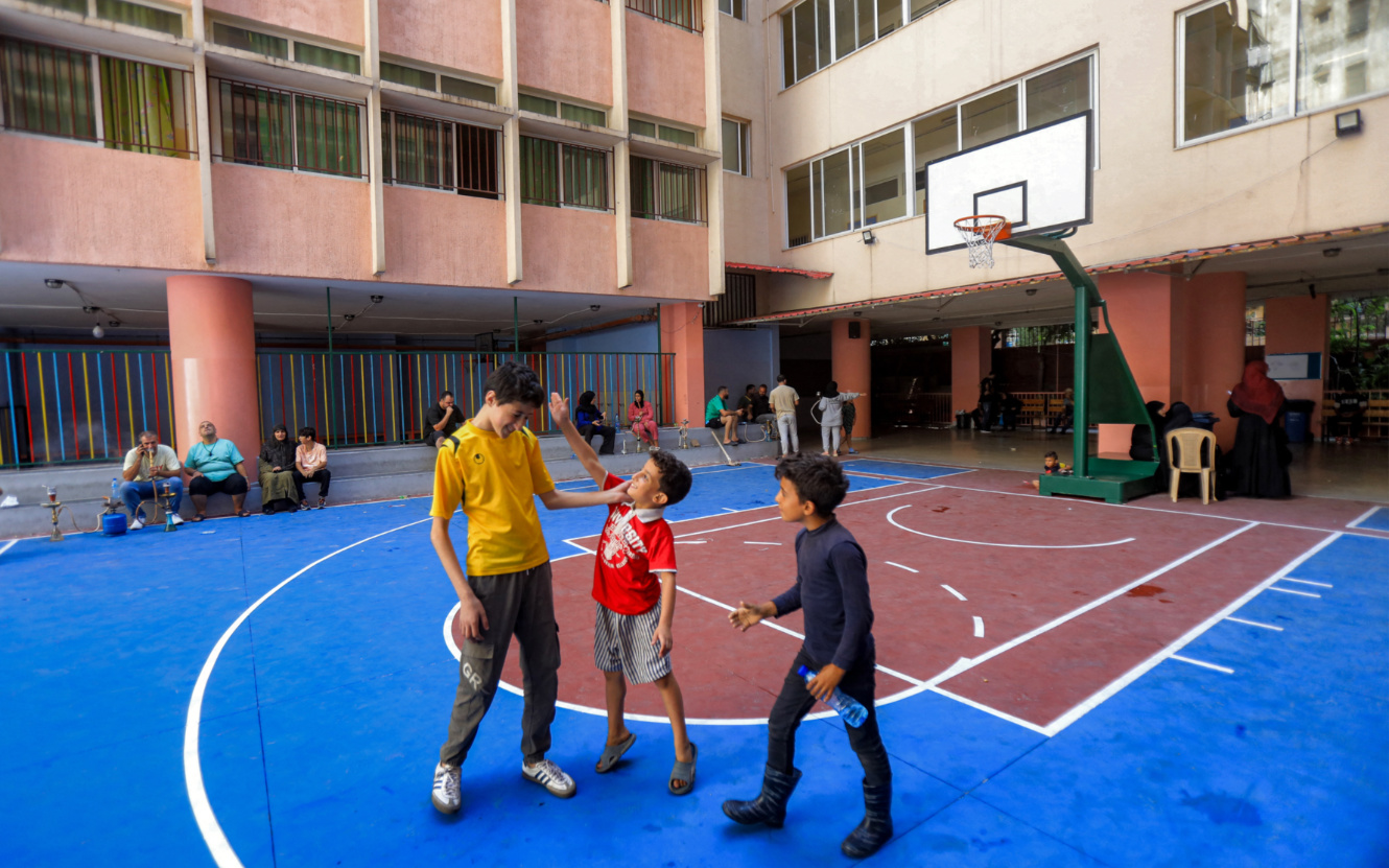 Children play in a basketball yard in a school-turned-shelter for displaced Lebanese in Beirut on 24 September 2024 (AFP)