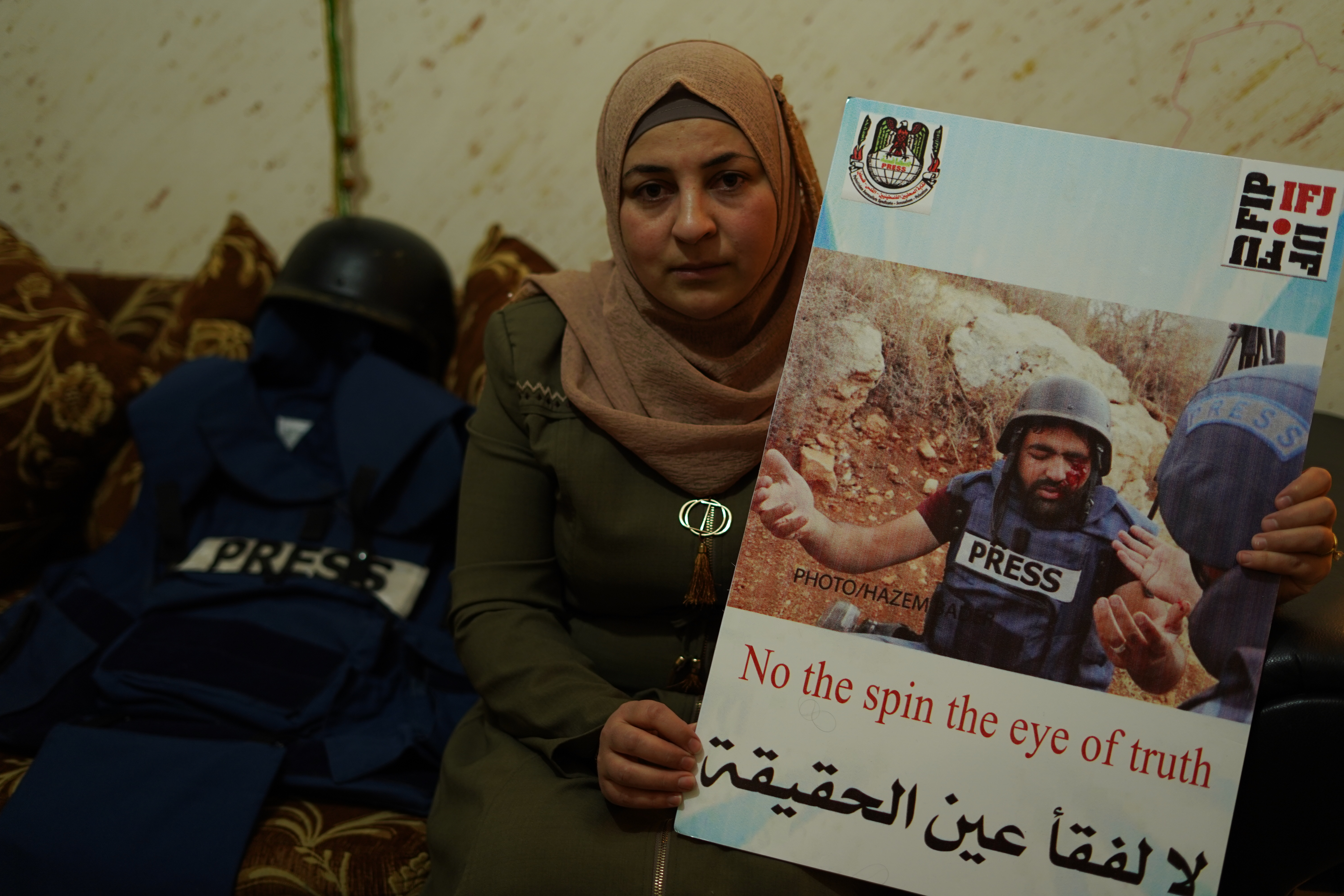 Welaa Amarneh holds a picture of her husband after he was shot in the eye by Israeli forces (MEE/Akram al-Waraa)