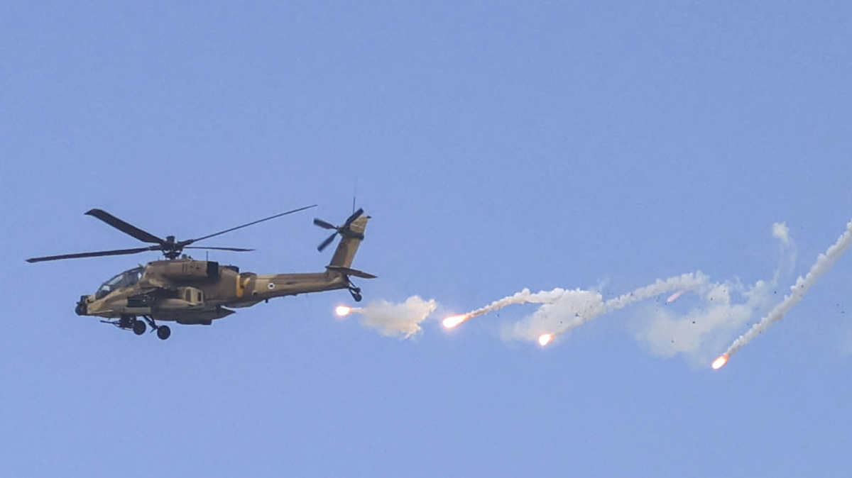 An Israeli Air Force AH-64 Apache attack helicopter releases flares during an Israeli army raid in Jenin in the occupied West Bank on 19 June 2023.