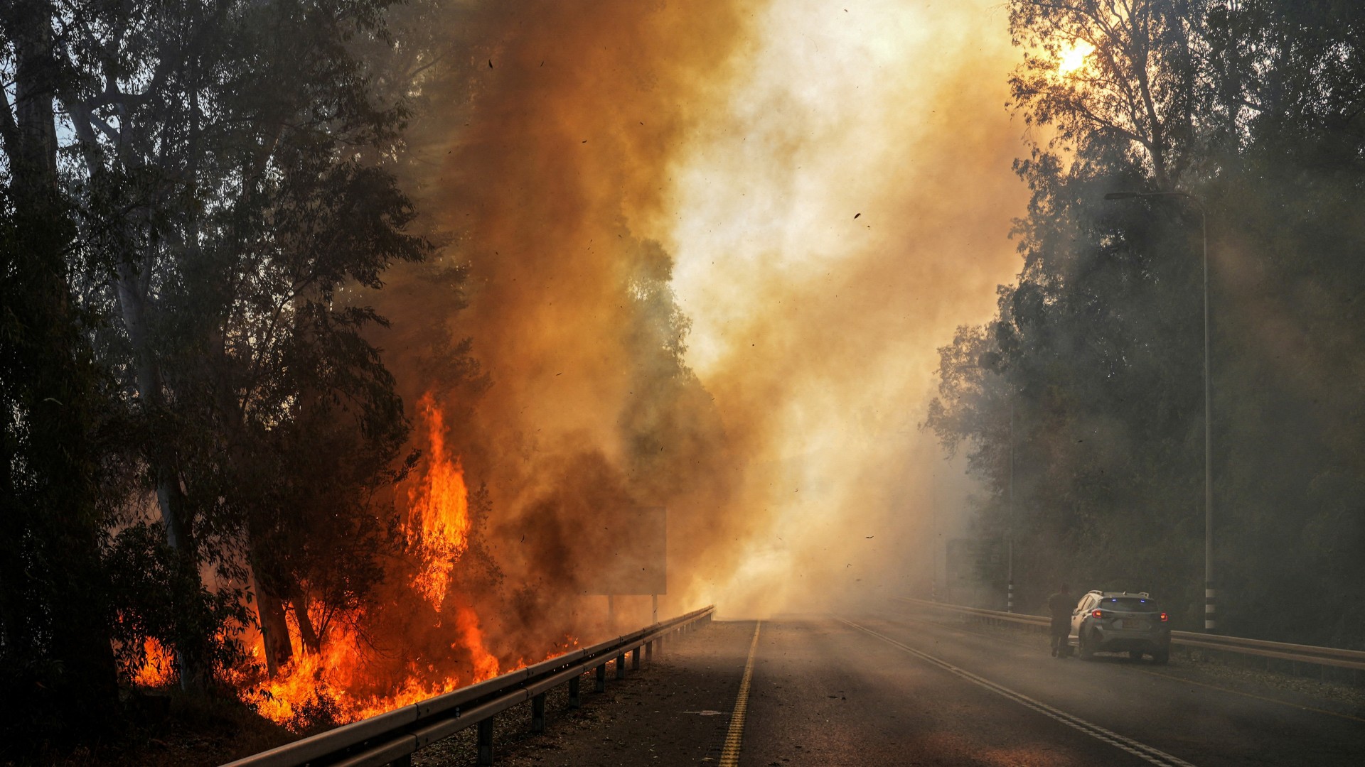 Flames seen at the side of a road close to the border with Lebanon, in northern Israel, 4 June (Reuters/Ayal Margolin)