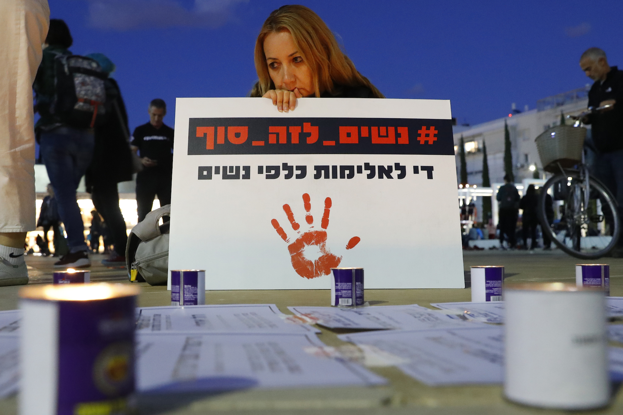 Israeli woman holds placard at protest against domestic violence AFP