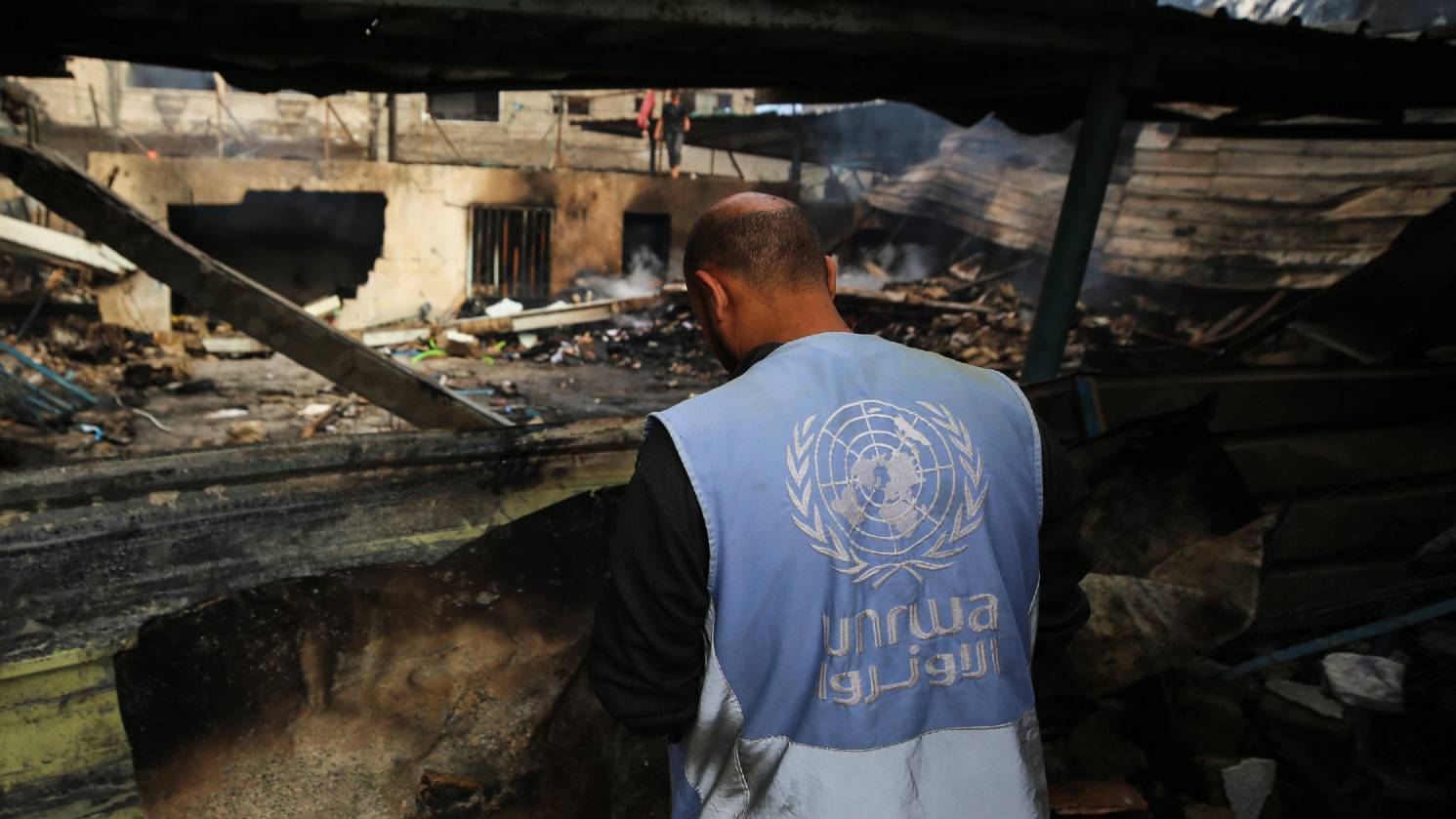 A Palestinian employee of UNRWA examines the damage after an Israel strike on a school sheltering displaced people in Nuseirat refugee camp, Gaza, in May 2024 (Reuters)