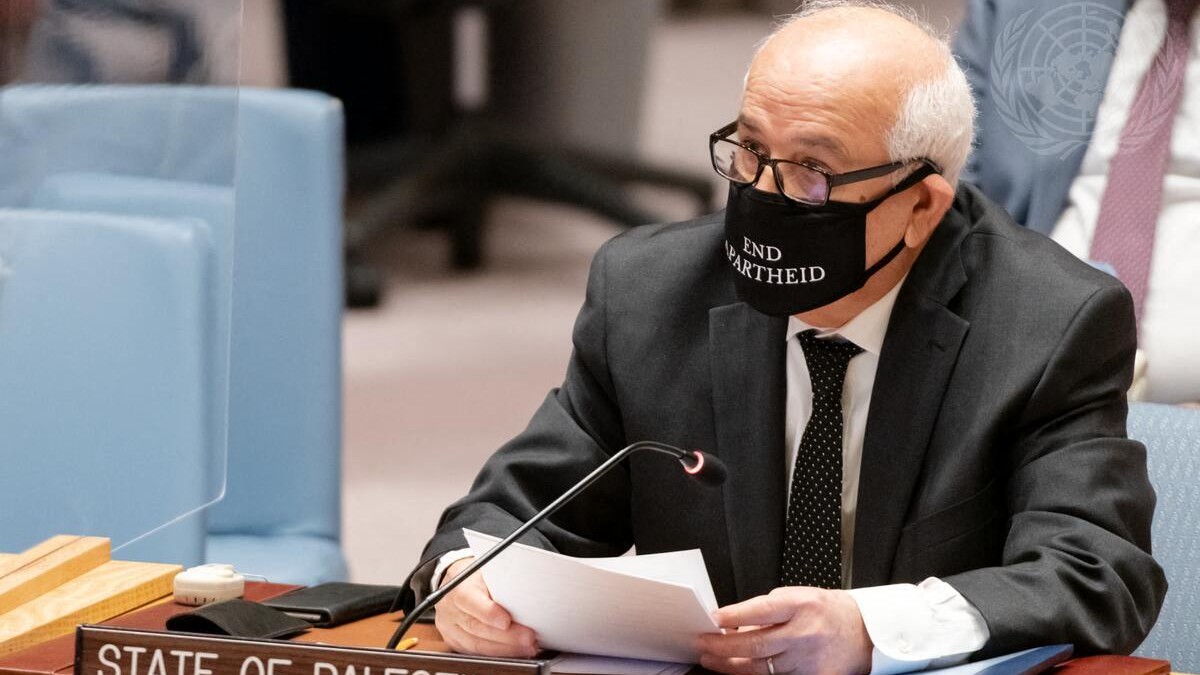 Palestinian ambassador to the UN Riyad Mansour wears a mask saying "End Apartheid" as he addresses a Security Council meeting in New York City, on 23 February 2022 (AFP)