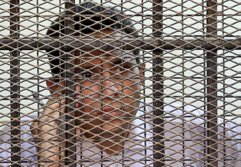 Mohsen al-Sukkari stands behind bars during his trial in the murder of Lebanese singer Suzanne Tamim in Cairo in 2010 (AFP)