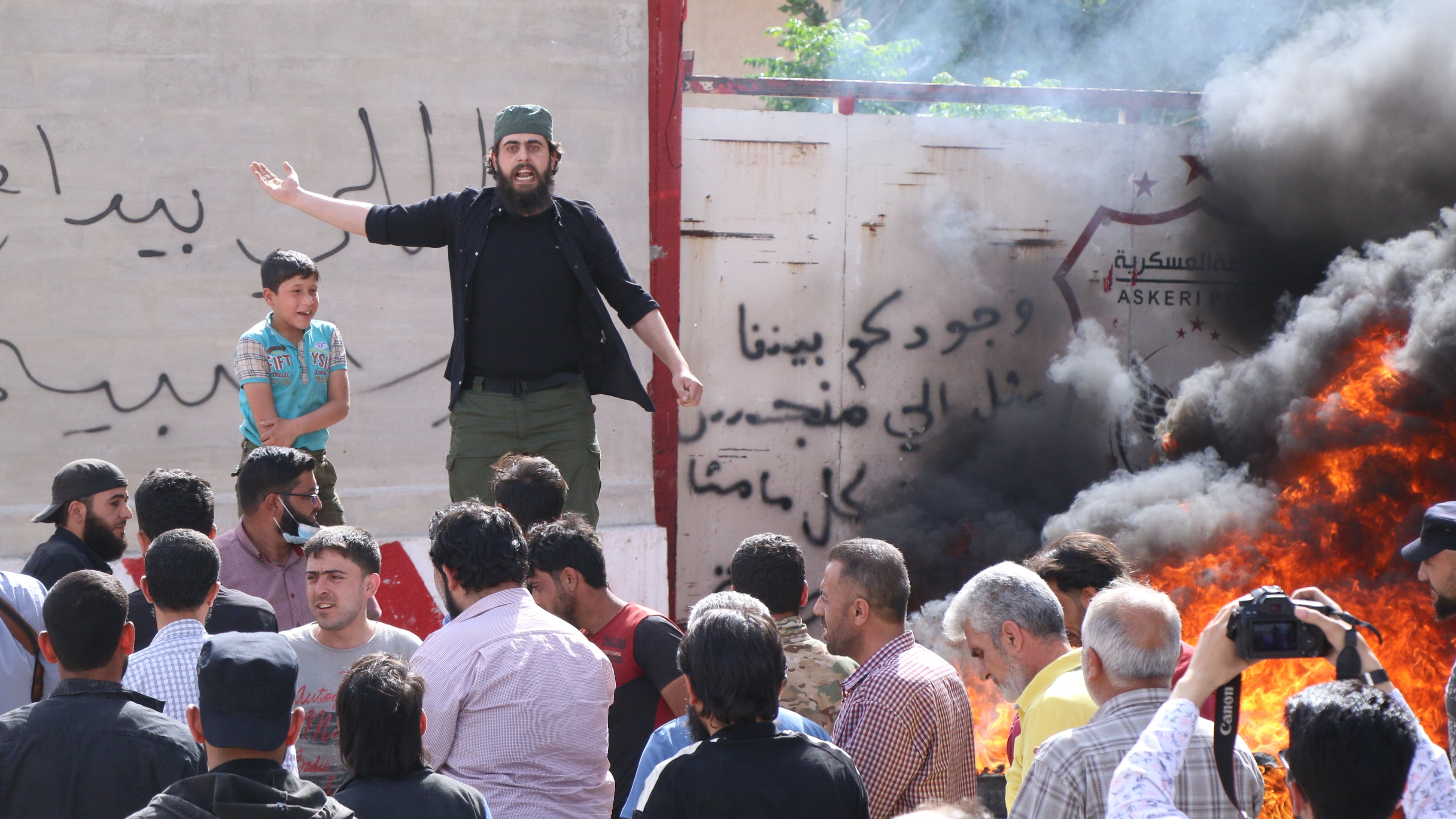 Protesters gather outside a military police station in al-Bab city in northwest Syria on 22 May 2022. (MEE/Walid al-ldlibi)