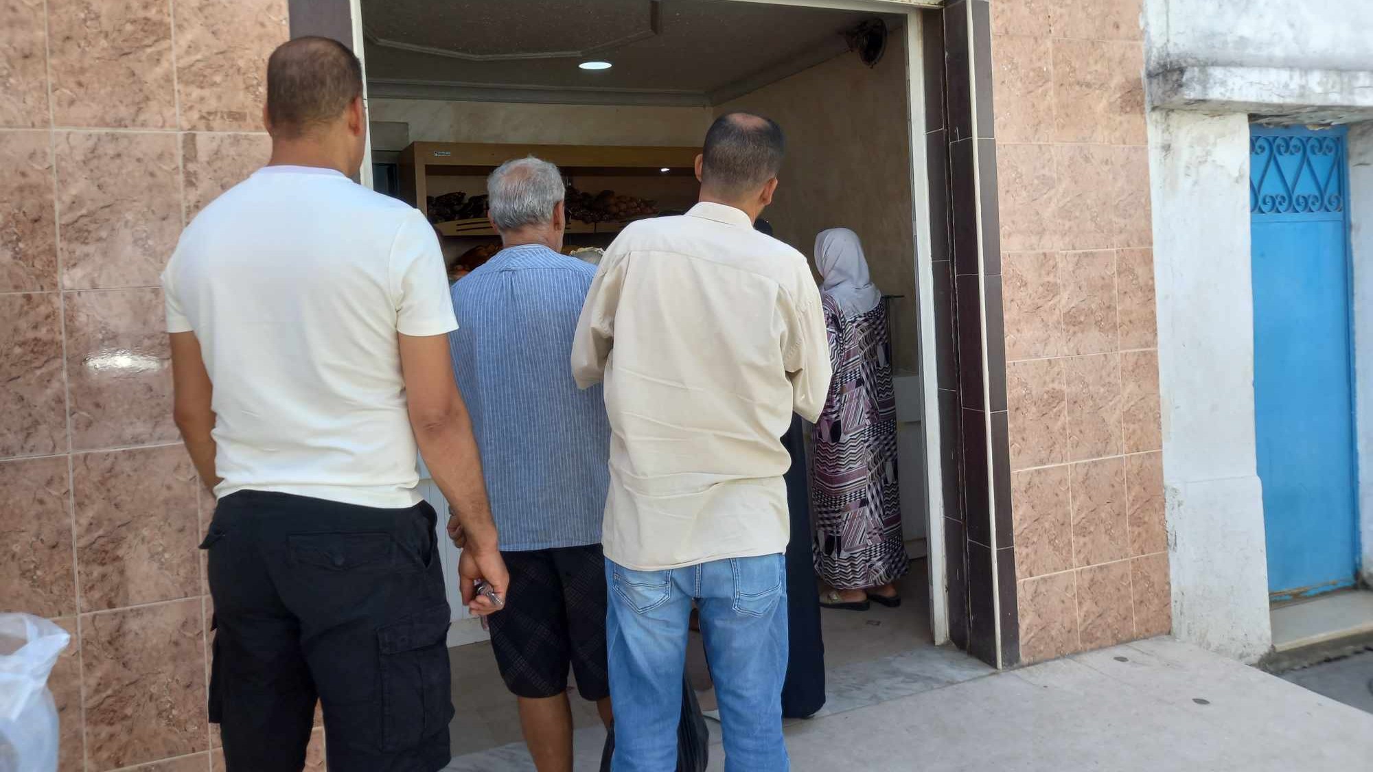 Tunisians queue up to buy bread a bakery in the capital Tunis on 07 August 2023 (MEE/Stephen Quillen)
