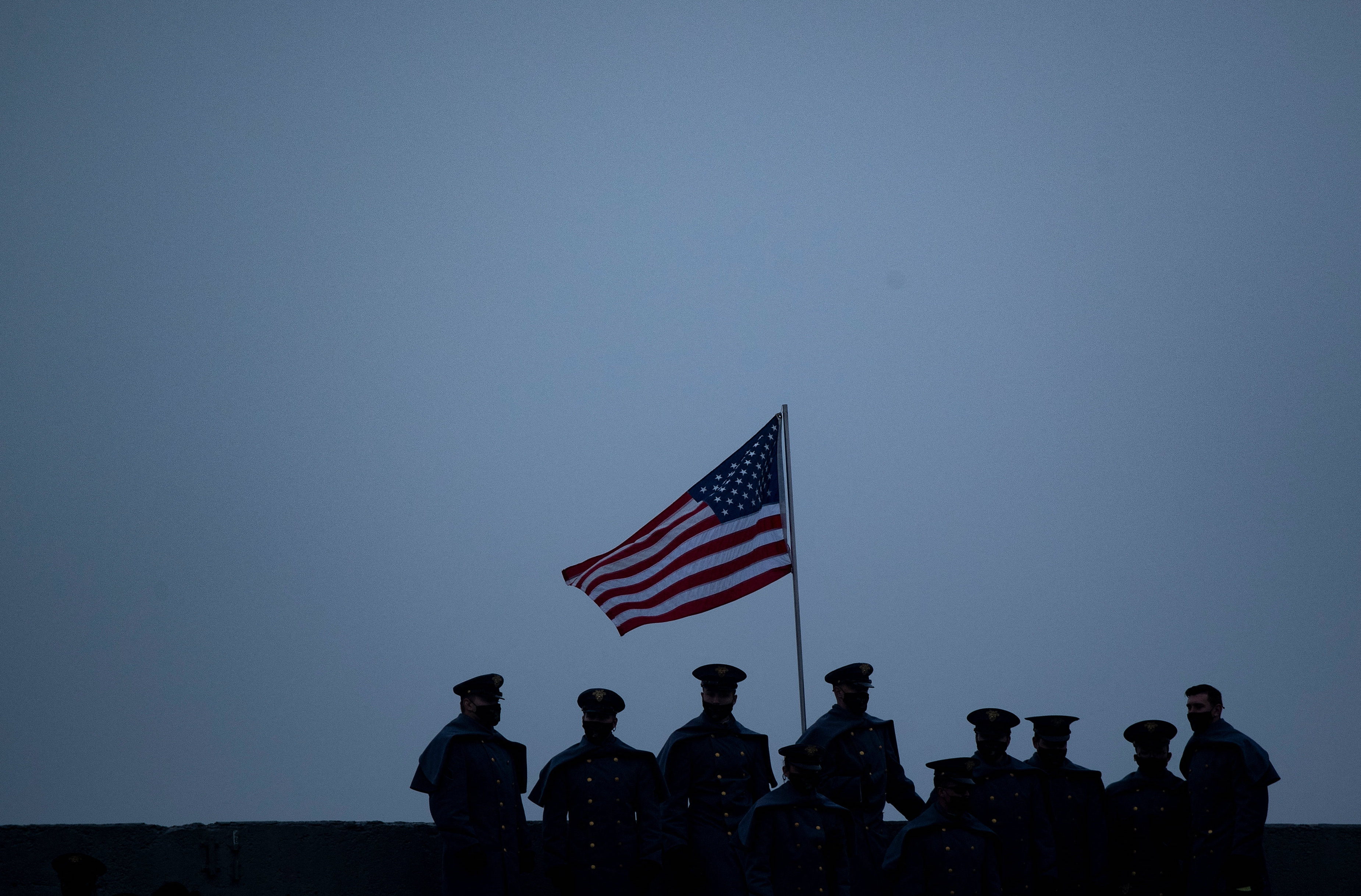 Members of the military stand near the US National flag during the Army-Navy football game at Michie Stadium on 12 December, 2020 (AFP)